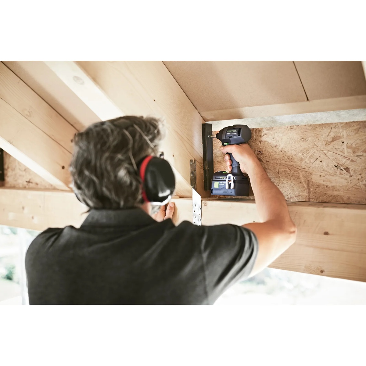 Festool TID 18 impact driver fastening hardware inside a wood framing corner where compact size helps reach a tight interior space