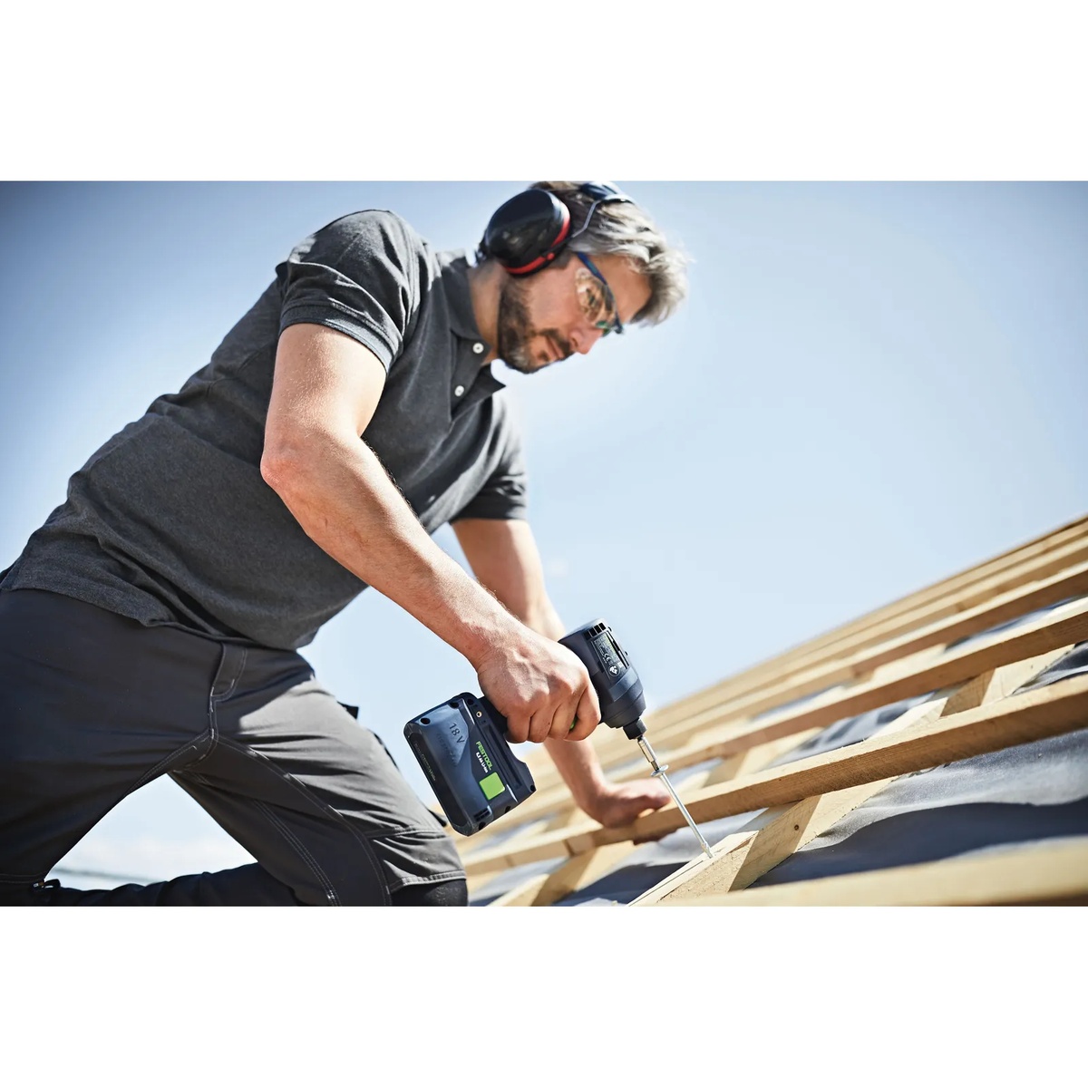 Festool 577616 QUADRIVE TPC 18/4 Cordless Hammer Drill and TID 18 Cordless Impact Screwdriver Combo Kit w/ Systainer3 in use driving a long fastener into roof framing lumber on a jobsite