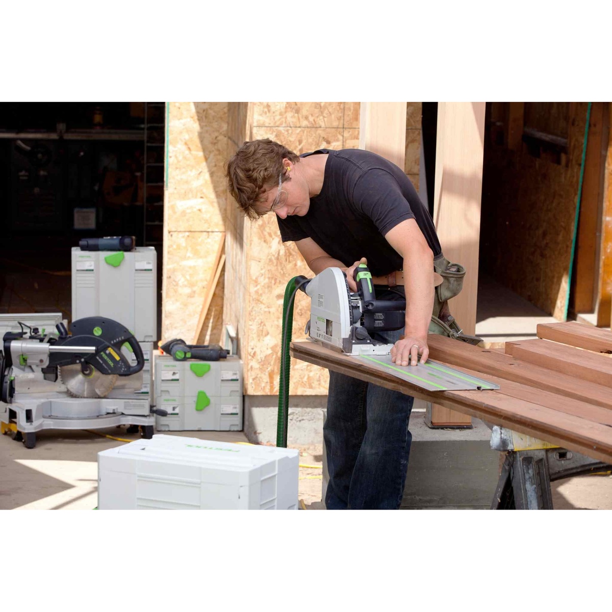 Festool TS 75 EQ Plunge Cut Track Saw cutting long hardwood boards on a guide rail at a real jobsite workbench