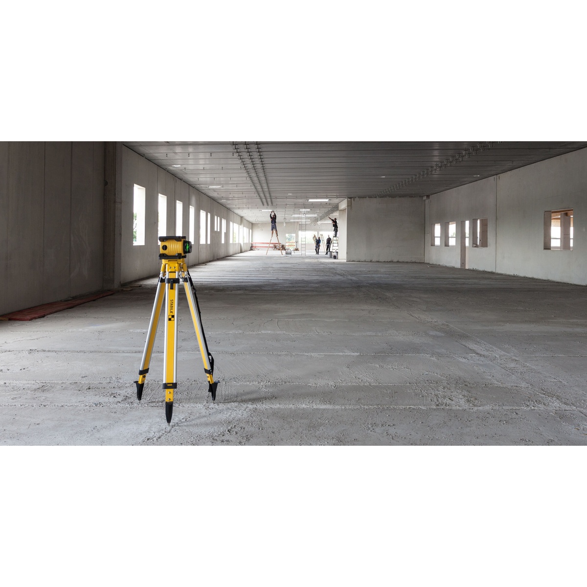 Stabila 07645 LAR 160 G Rechargeable Battery supporting rotary laser layout work in a large indoor construction space with the laser set on a tripod for leveling