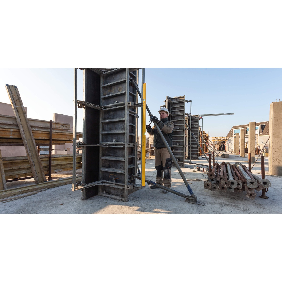 Stabila Type 80 ASM-2 spirit level used vertically to align a tall metal form on a construction site