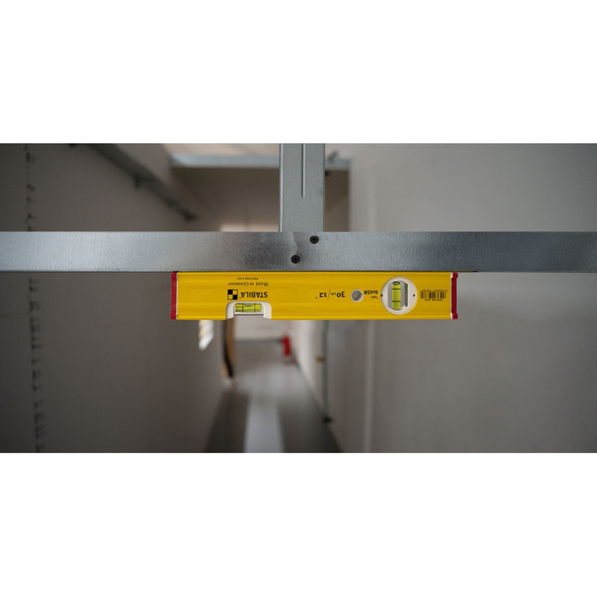 Stabila 29940 level set short spirit level checking level on a metal rail inside a cabinet or framing installation