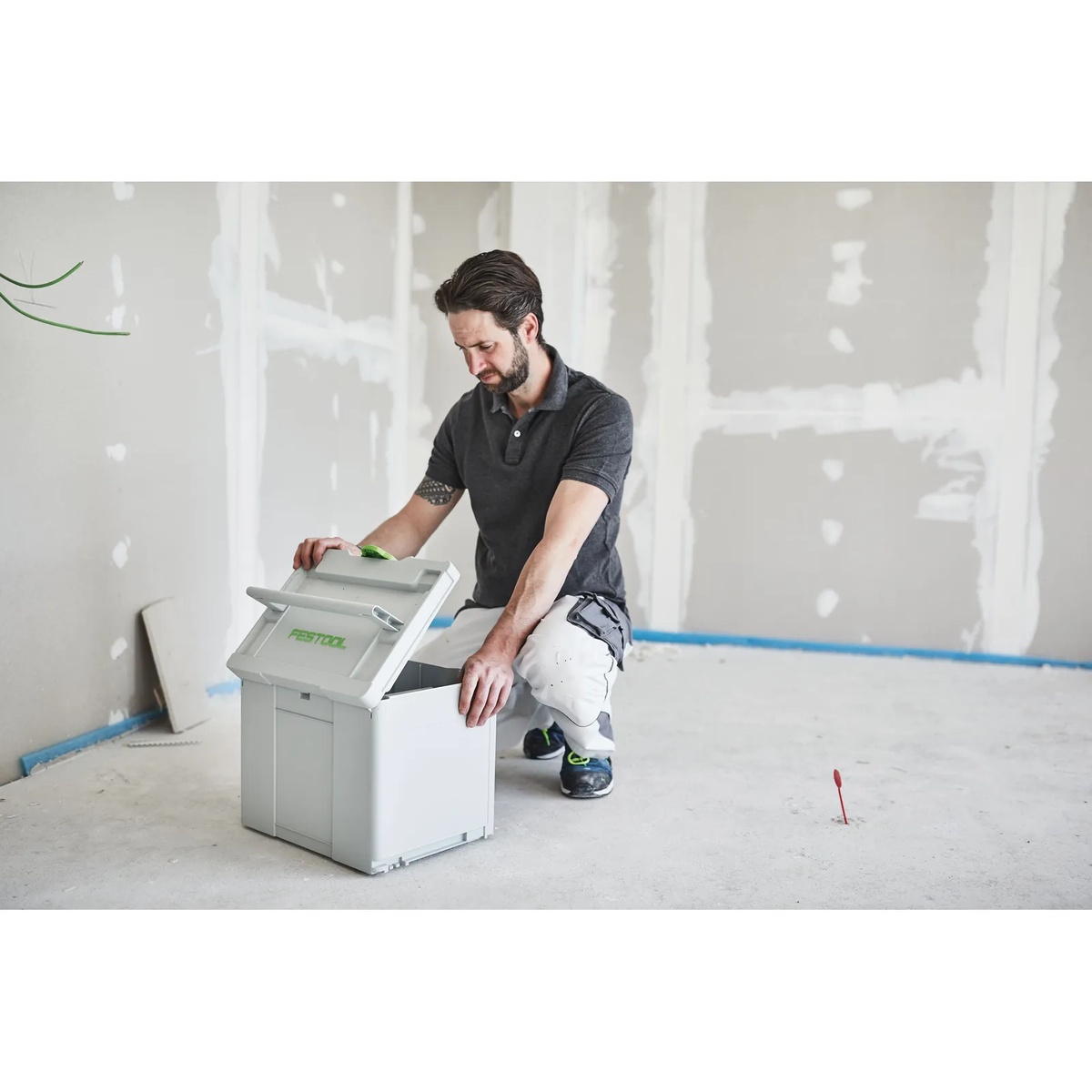Contractor opening the Festool SYS-STF-D225 Systainer3 in an unfinished interior room during drywall prep and sanding setup