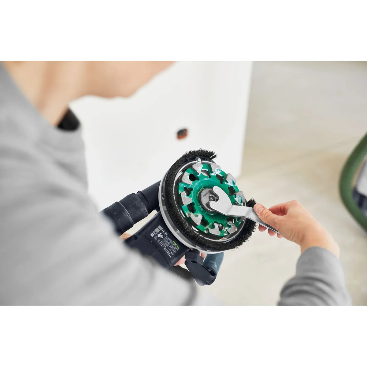 Festool 769166 DIA STONE-D130 PREMIUM Diamond Disc installed on a Festool RG 130 grinder during a disc change on a concrete prep job