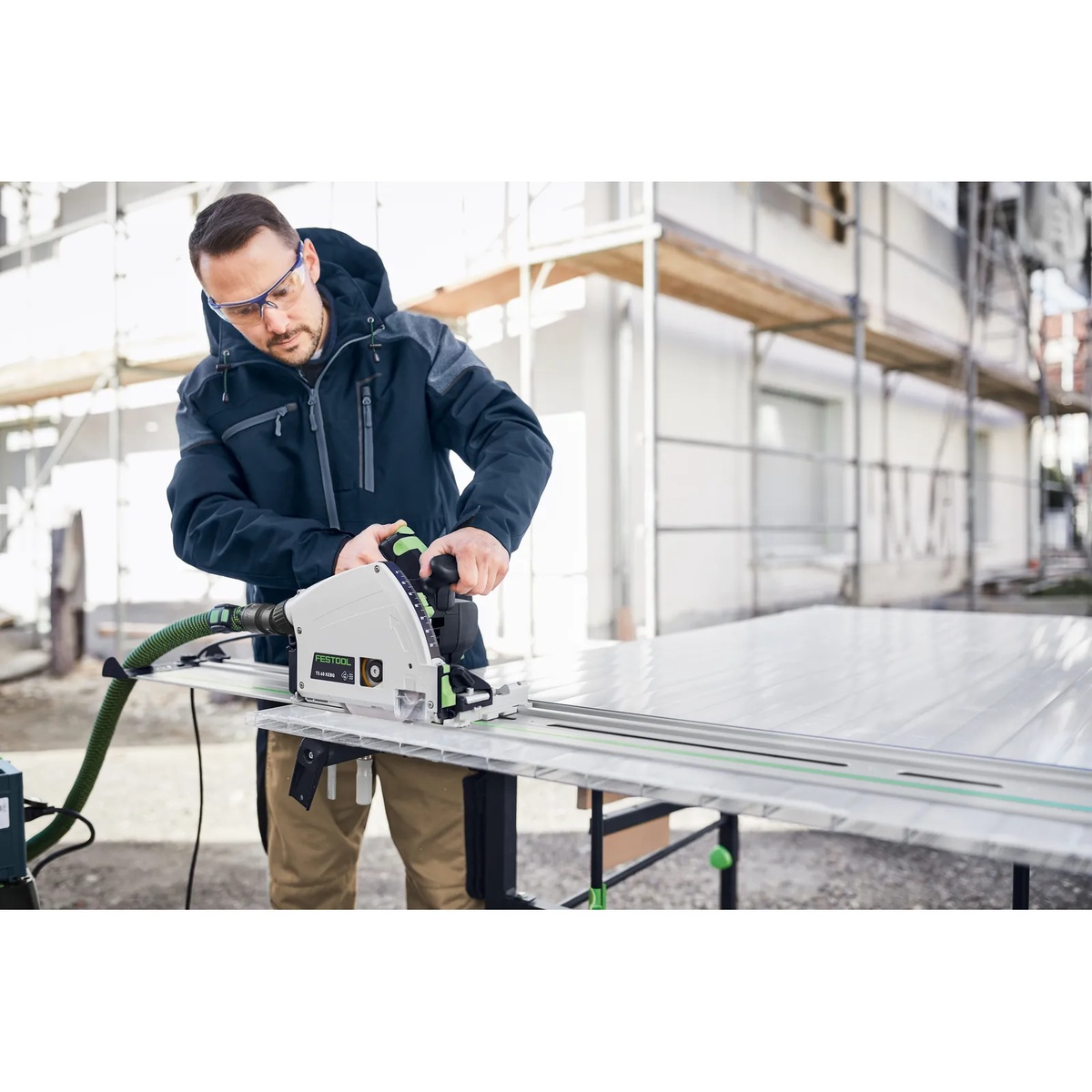 Festool 205774 aluminium plastics saw blade installed in a Festool plunge saw cutting a large panel on a guide rail at a jobsite table setup