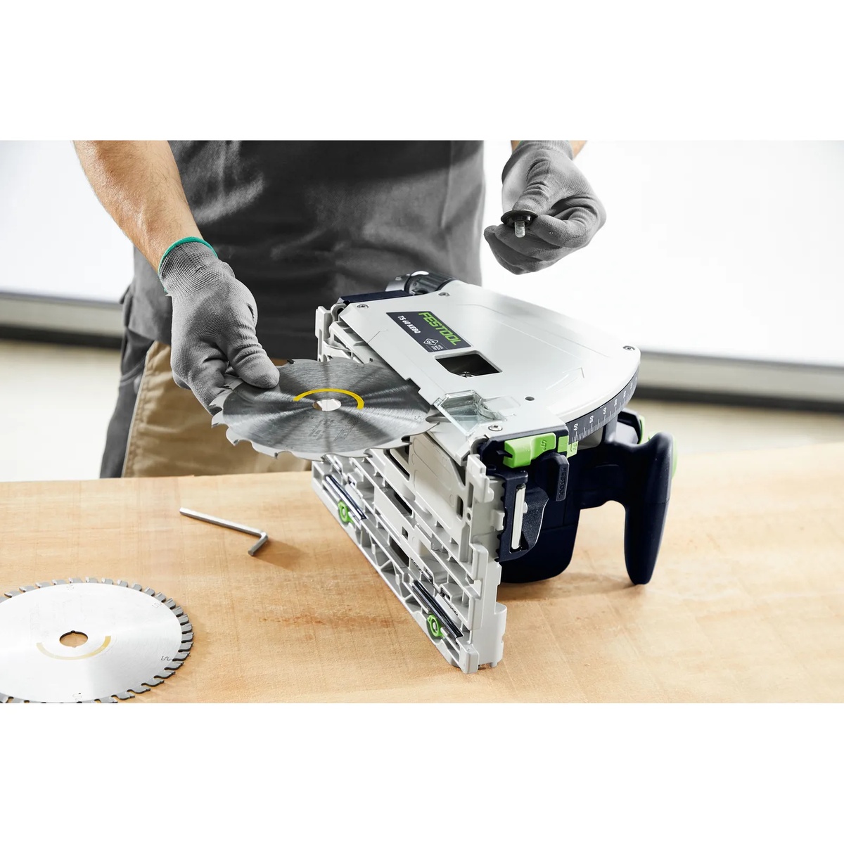 Festool TS 60 KEB plunge cut track saw with blade being changed on a workbench, showing the saw ready for setup and maintenance between cuts