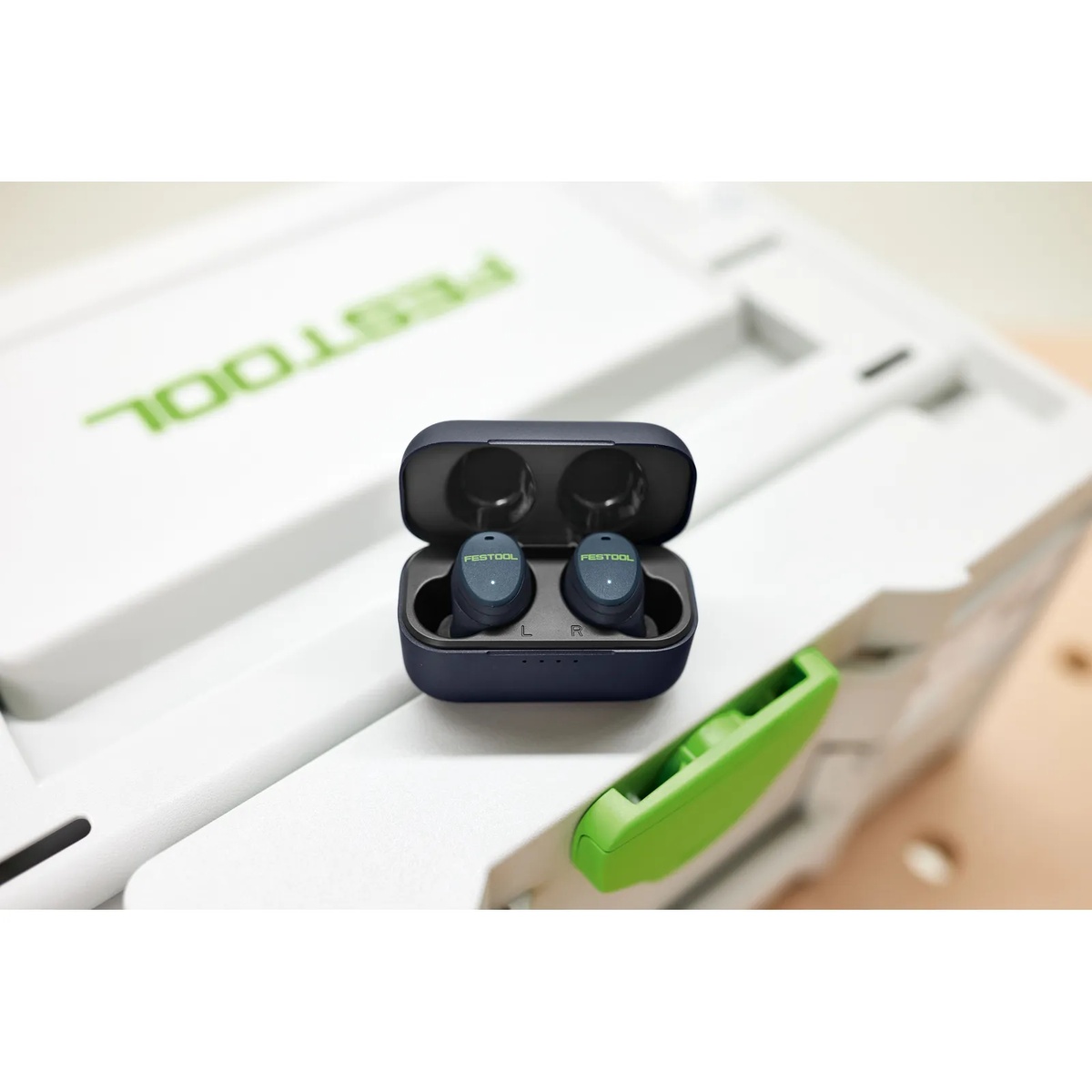 Festool GHS 25 I hearing protection earplugs sitting in the charging case on a Festool toolbox, highlighting conversation mode and ready access in a workshop setting