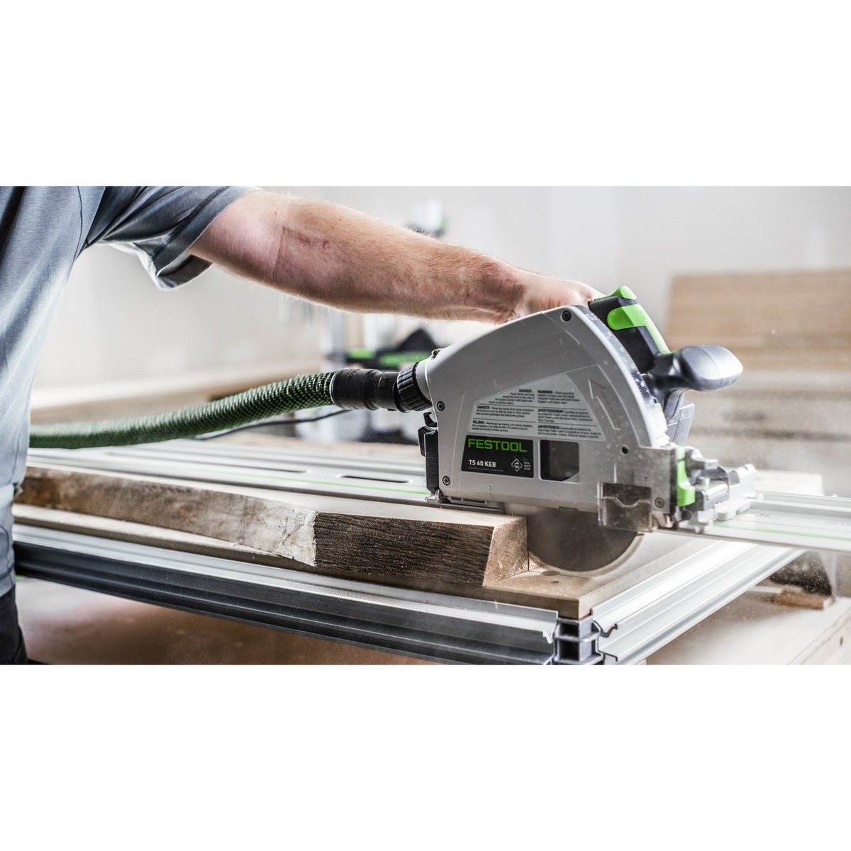 Festool 577422 TS 60 KEB-F-Plus-FS Plunge Cut Track Saw Set w/ 55-in. Guide Rail making a plunge cut in thick wood on a guide rail in an indoor woodworking setup