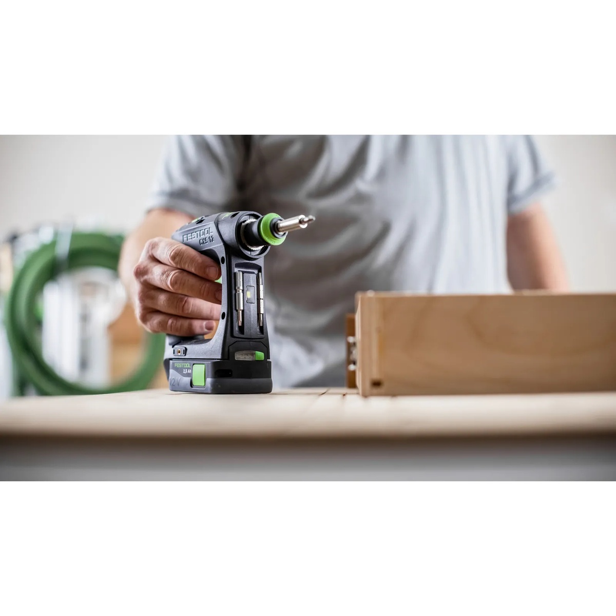Festool CXS 12 2.5Ah Cordless Drill Kit set beside a wood cabinet component in a workshop, ready for drilling and fastening