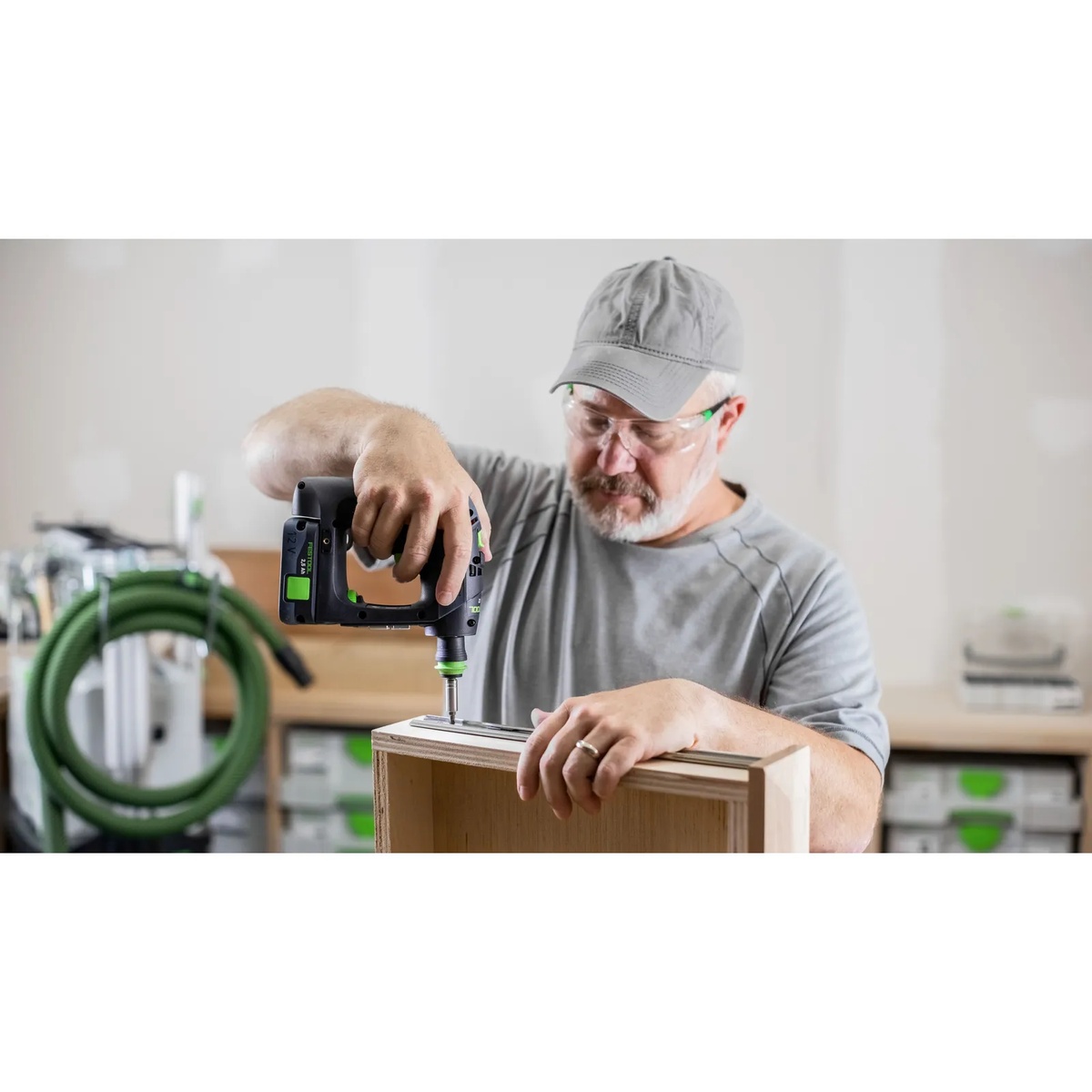 Festool CXS 12 2.5Ah Cordless Drill Kit driving a fastener into a plywood cabinet during furniture assembly in a workshop