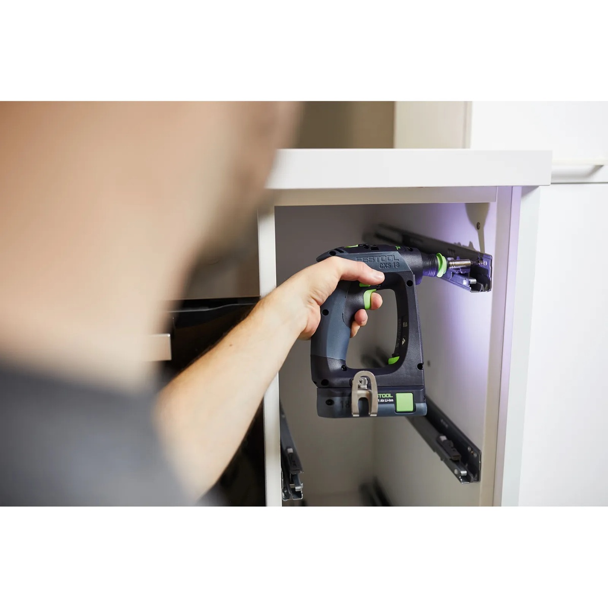 Festool 576887 CXS 18 BASIC Cordless Drill driving hardware inside a cabinet during installation work in a finished interior