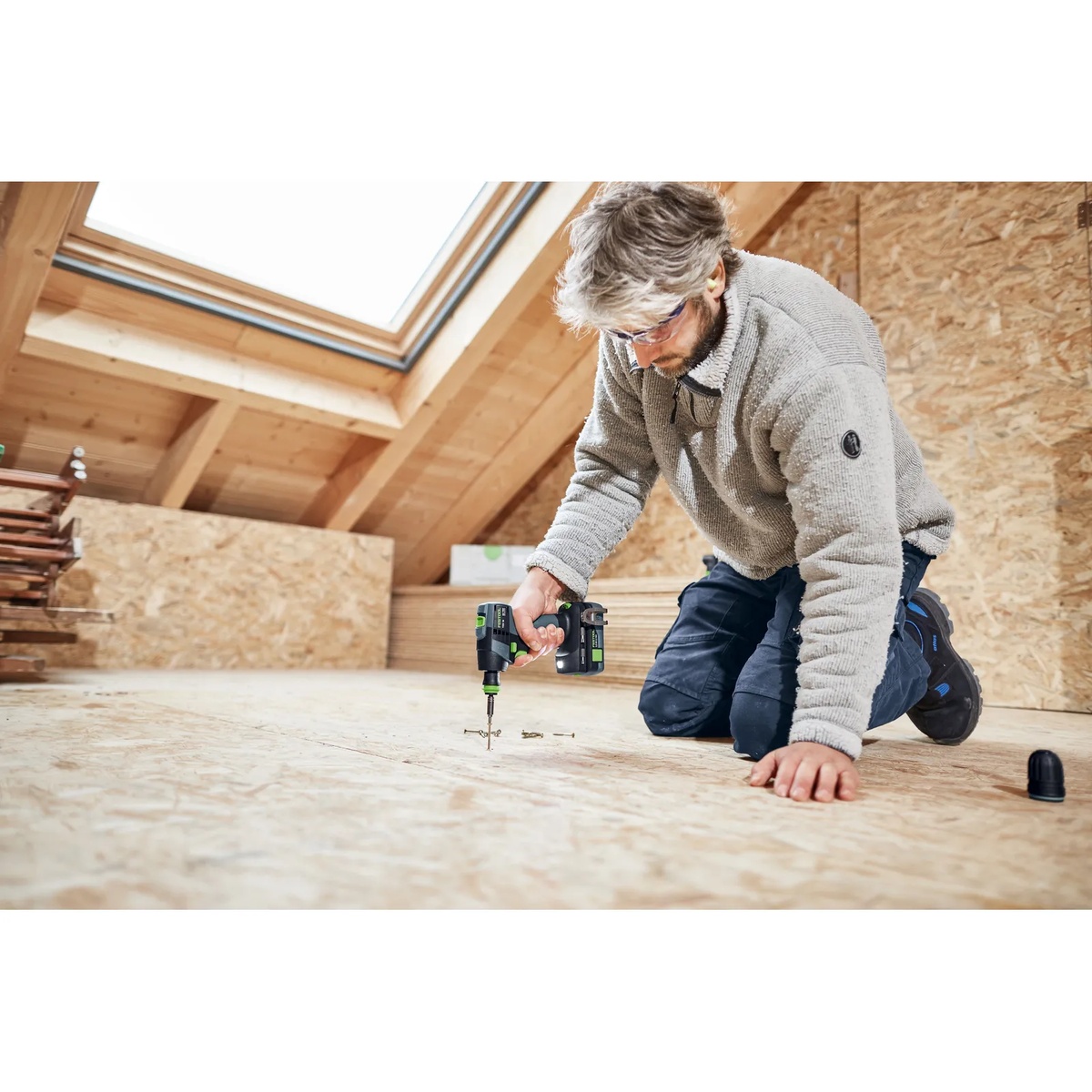 Festool TXS 18 BASIC Cordless Drill driving screws into wood subfloor material during interior finishing and remodeling work