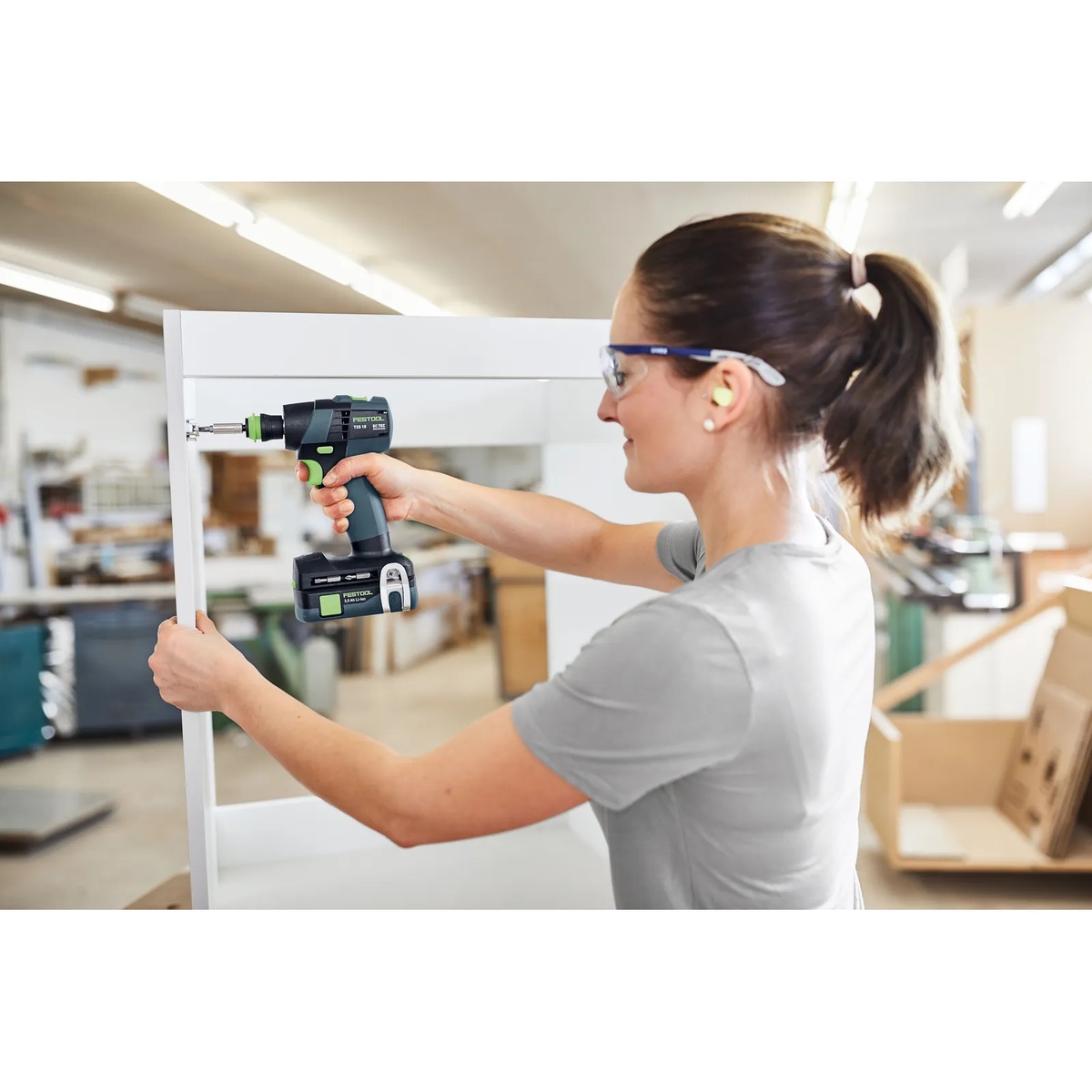 Festool TXS 18 BASIC Cordless Drill driving a fastener into cabinet framing during furniture and cabinet assembly work in a shop