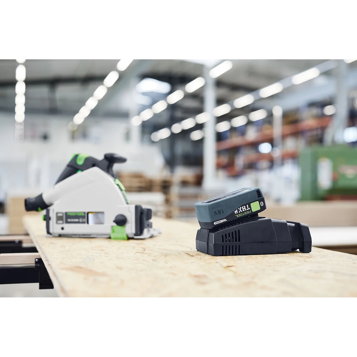 Festool 576954 SCA 16 Rapid Charger charging an 18V battery pack on a workbench in a shop next to a cordless track saw