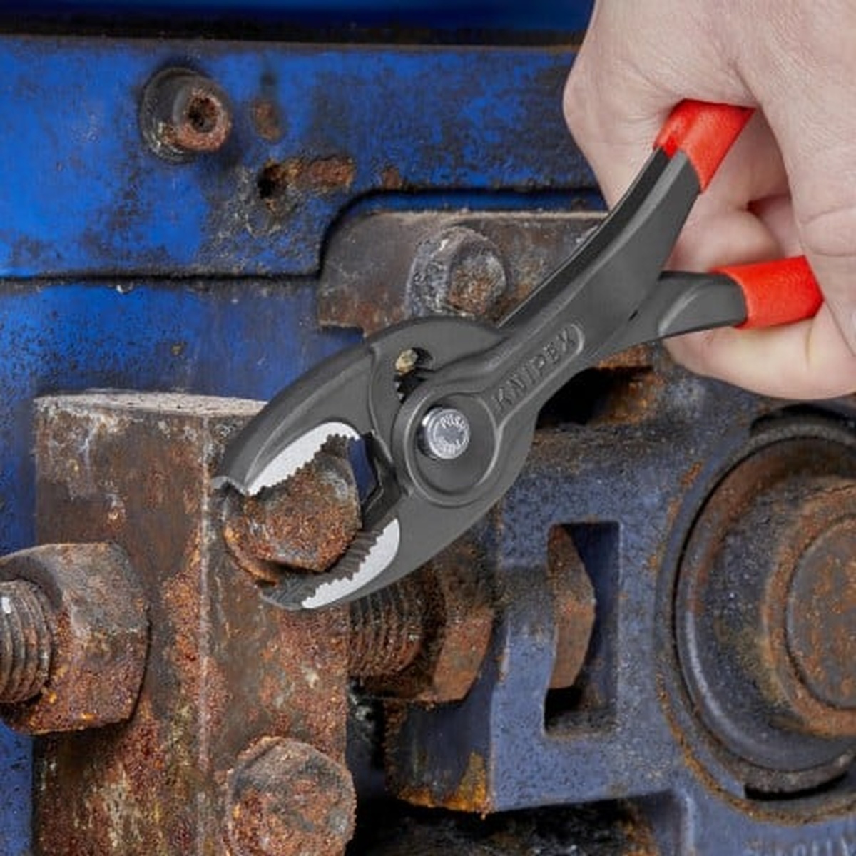 Knipex 9K 00 80 156 US 3-Piece Top Selling Pliers Set TwinGrip pliers gripping a rusted bolt on industrial equipment during fastener removal