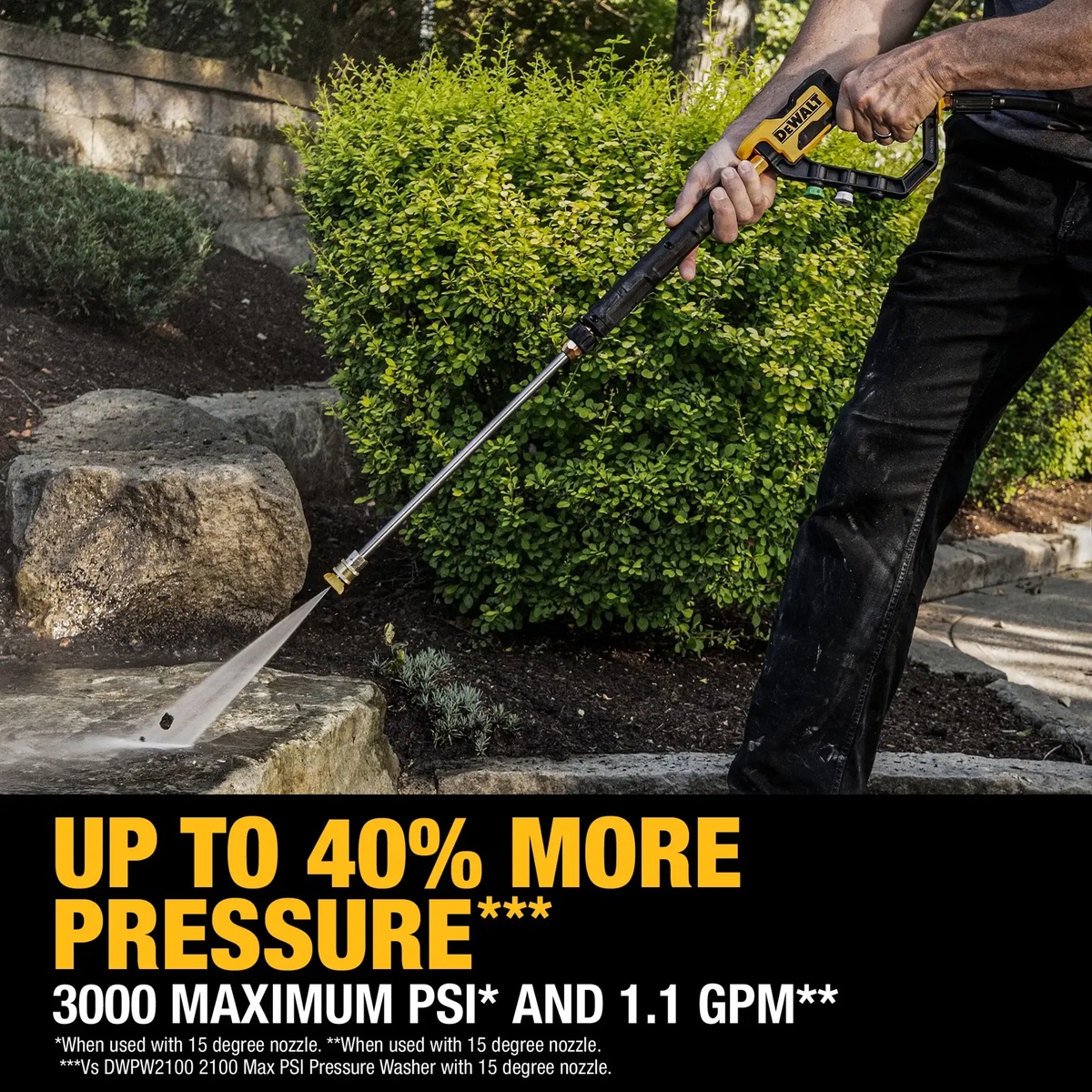 DEWALT 3000 MAX PSI 1.1 GPM Brushless Electric Jobsite Pressure Washer cleaning stone and outdoor hardscape in a residential landscape setting