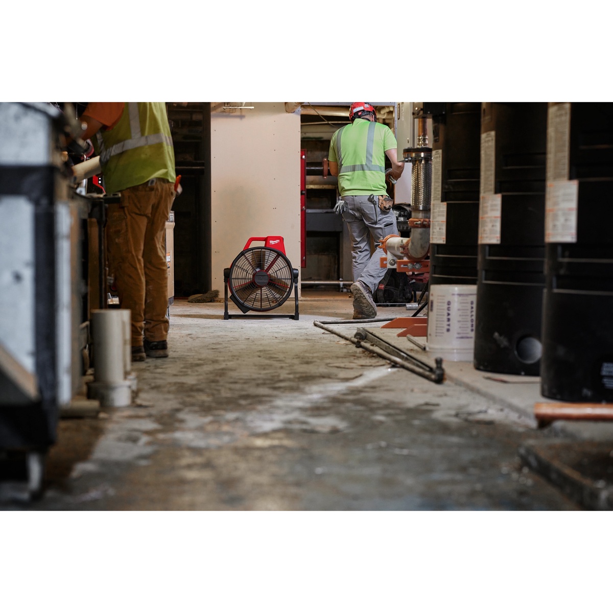 Milwaukee M18 Brushless 18 inch Fan moving air across an active indoor construction jobsite for cooling and ventilation