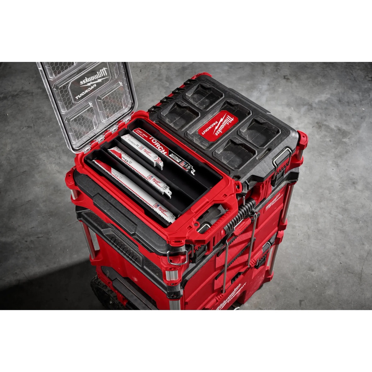 Milwaukee 49-22-5640 22PC SAWZALL Blade PACKOUT Kit opened on top of a PACKOUT stack on a jobsite floor, showing sorted reciprocating saw blades ready for metal and wood cutting work