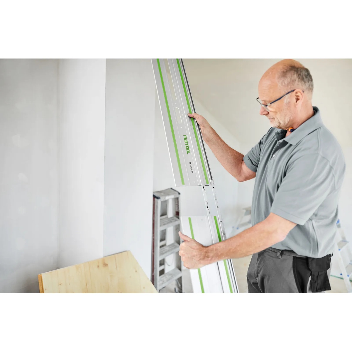Festool FS 1400/2-KP-Set Guide Rail being carried into an interior jobsite for wall and work surface cutting tasks