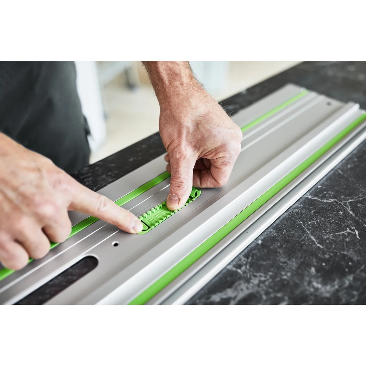 Close-up of the Festool FS 1400/2-KP-Set Guide Rail removable adhesive pad being installed on a work surface for secure grip