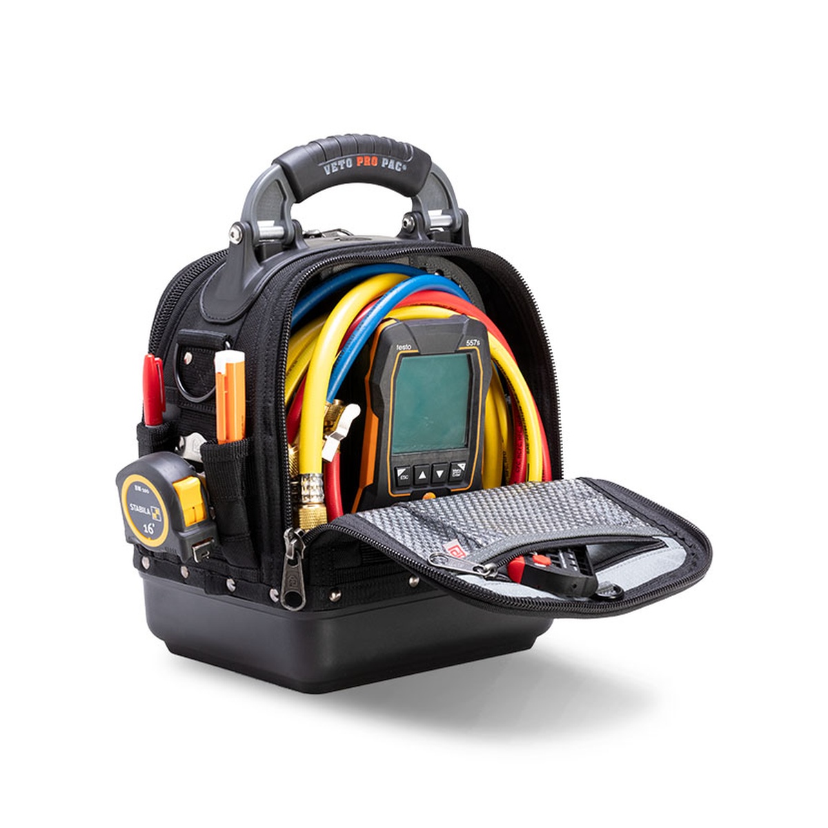 Veto Pro Pac TECH-MC BLACKOUT tool bag opened on a work setup showing organized storage for hoses, a digital meter, and service tools inside the main compartment