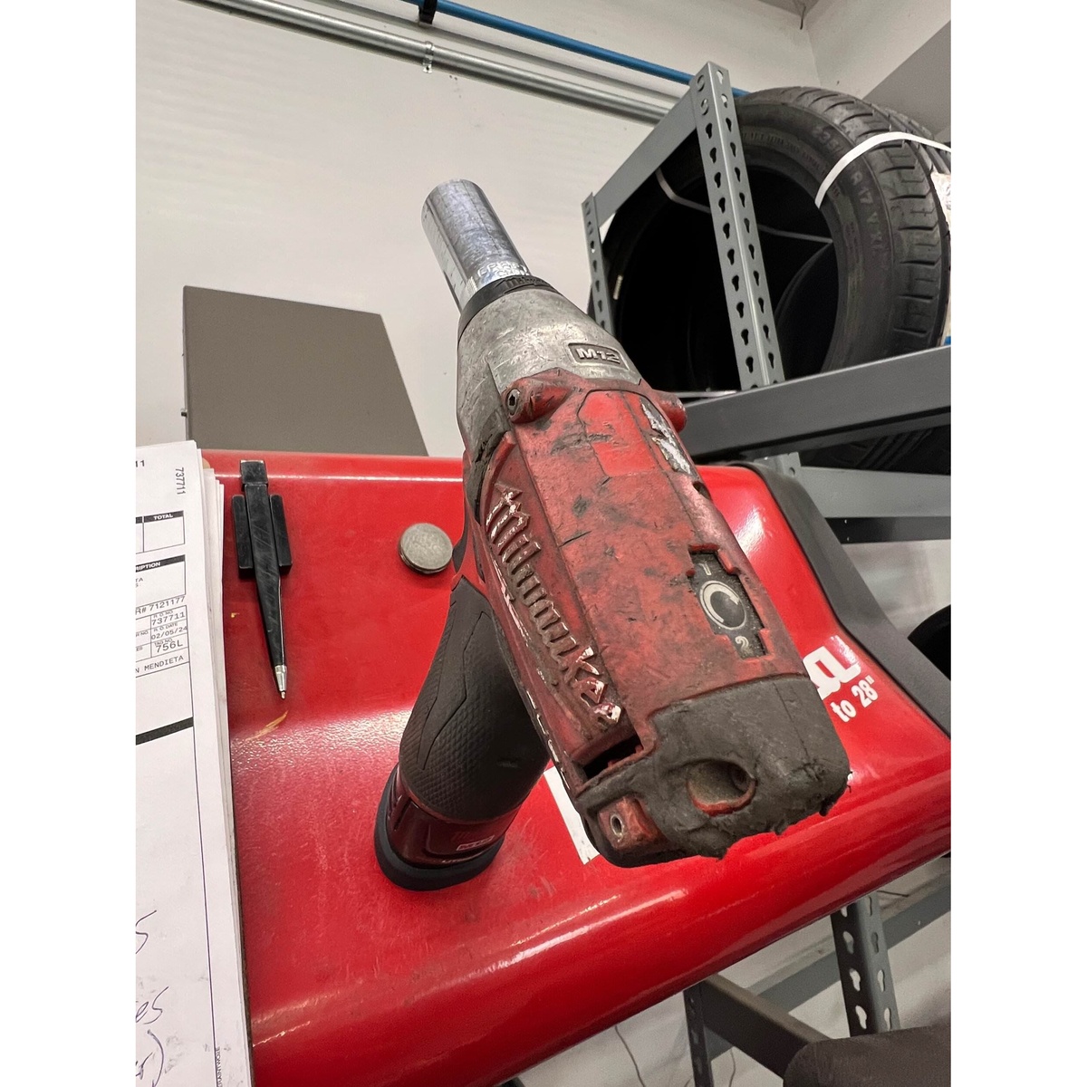 STS Auto Design MW12TL Milwaukee M12 Tri-Lobe Magnet Battery Cover installed on a Milwaukee M12 tool resting on a steel tool chest in a shop