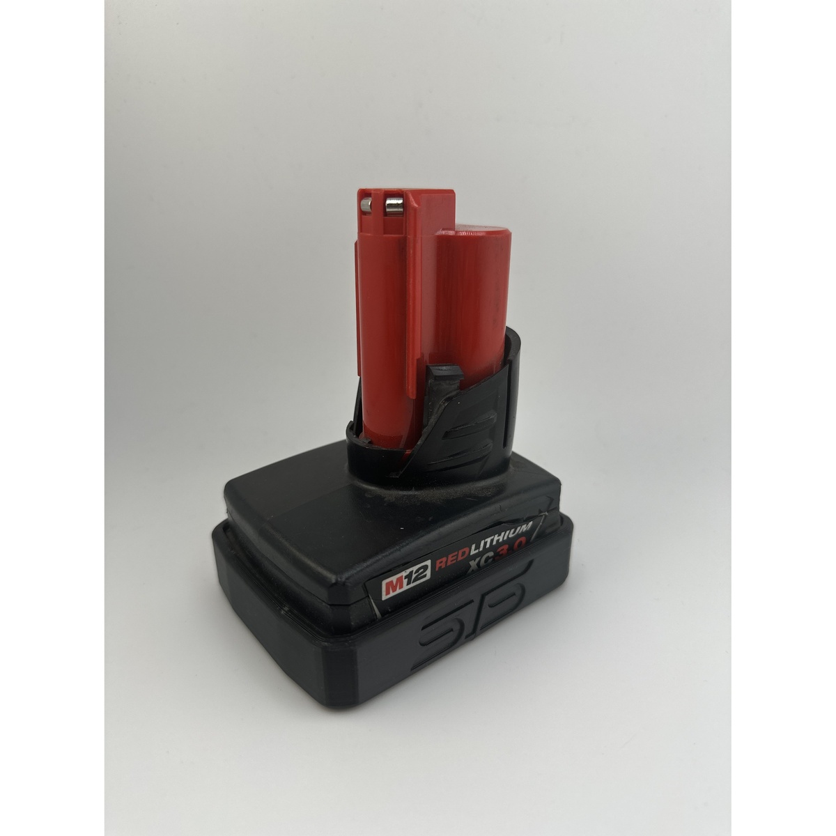 STS Auto Design MW12XC Milwaukee M12 XC Magnetic Battery Cover fitted to a Milwaukee M12 XC battery on a plain background showing the snug battery cover fit