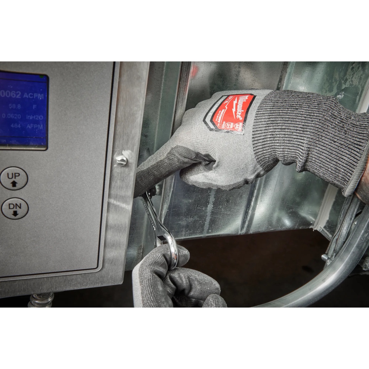 Milwaukee 48-22-2950 7-in-1 Multi-Bit Mini Ratchet tightening a fastener inside sheet metal equipment during service work in a tight mechanical space