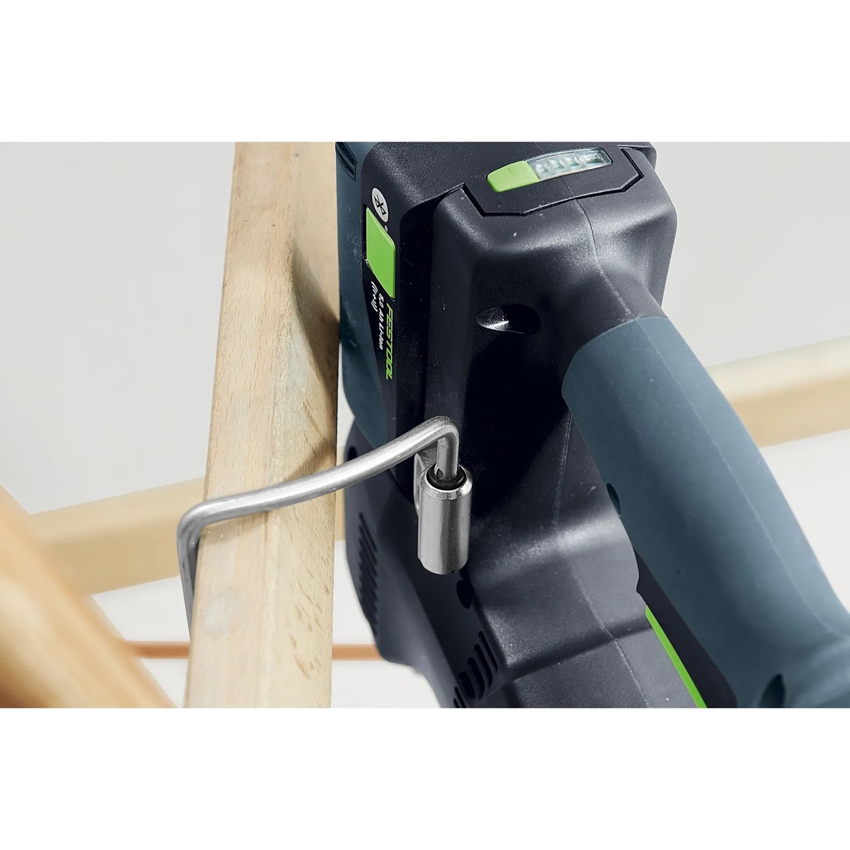 Festool KHC 18 EB-Basic Cordless Rotary Hammer Drill hanging from its scaffold hook on a wood rail for convenient storage during elevated jobsite work