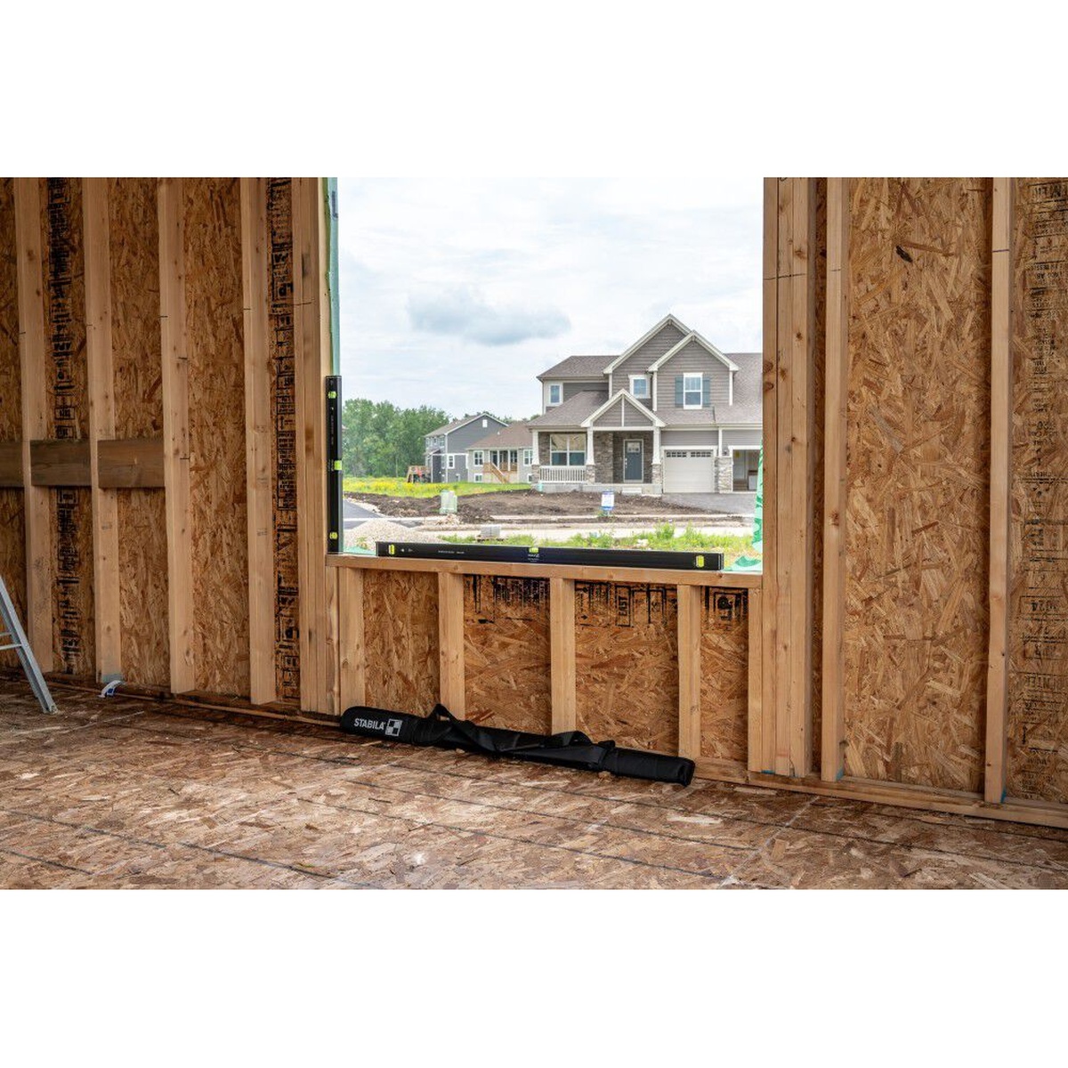 Stabila 29300 2-Piece Dark Shadow Type 80AS-2 24 in. / 48 in. Level Set checking level on framing at a window opening on a jobsite