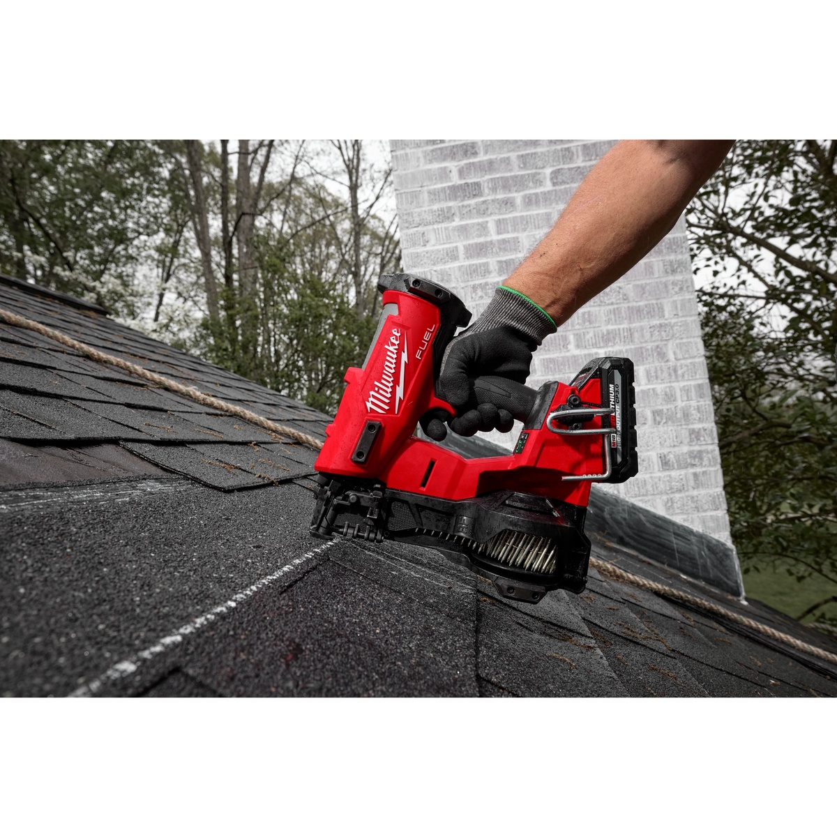 Milwaukee 2909-20 M18 FUEL Coil Roofing Nailer fastening asphalt shingles on a sloped residential roof during exterior repair work