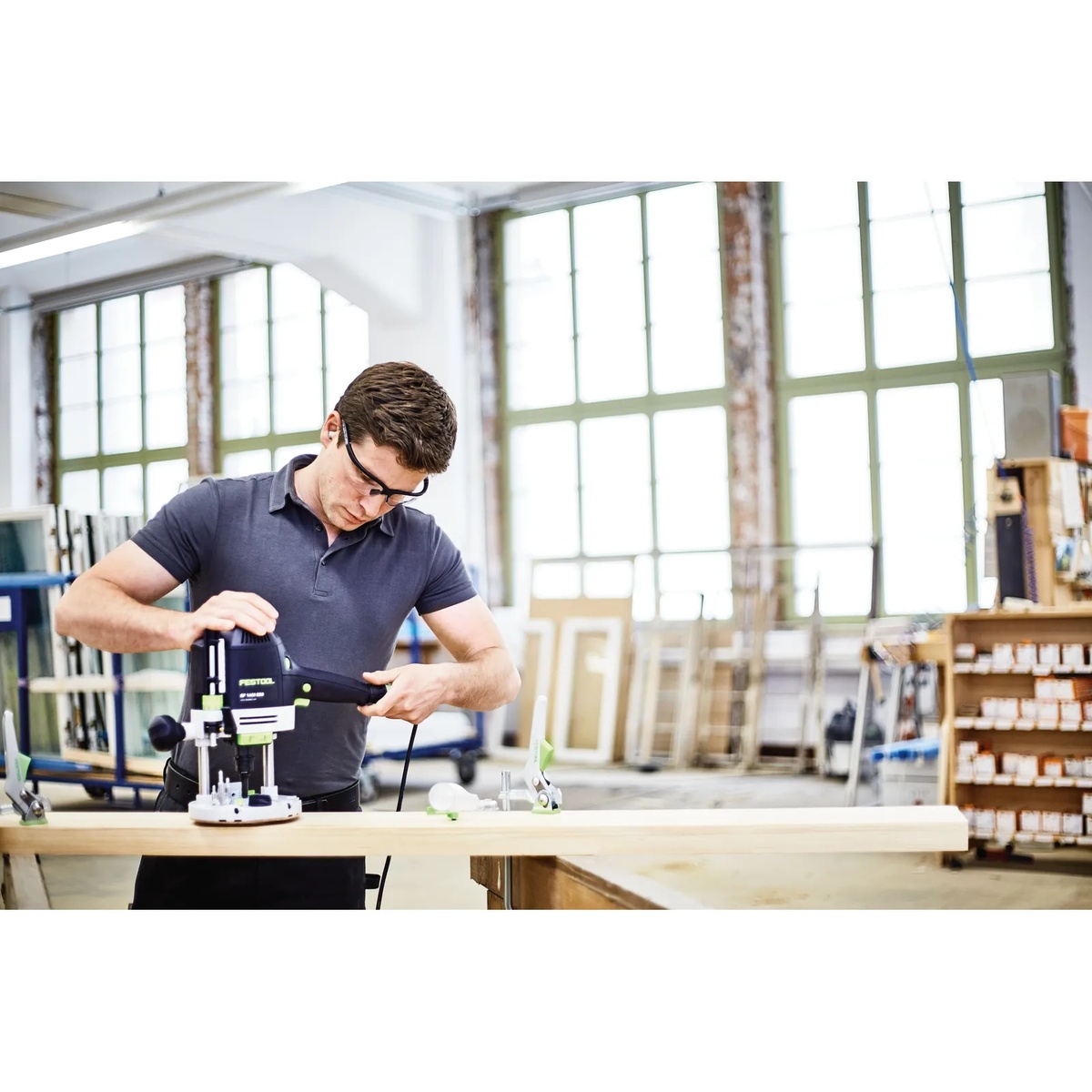 Festool 498979 Box-OF HW S8 Mix 10-Piece 8mm Shank Router Bit Holiday Value Set used with a router on a wood board in a workshop for edge profiling and groove work