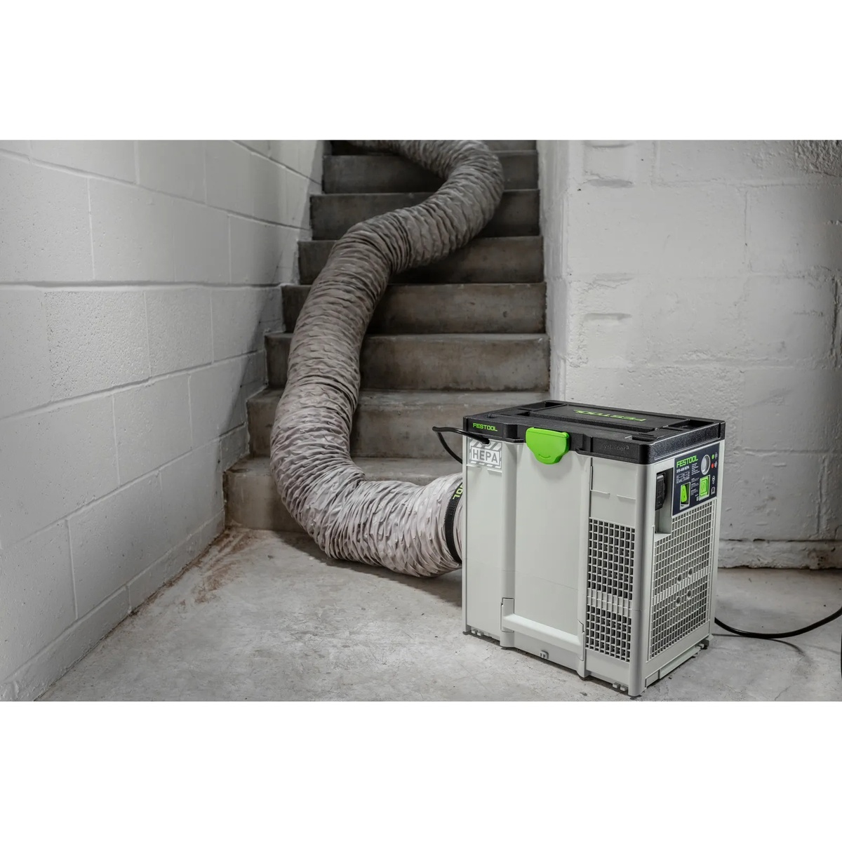 Festool 577790 SYS-AIR Air Filtration System running on an indoor jobsite with hose connected in a stairwell for dust control during renovation work