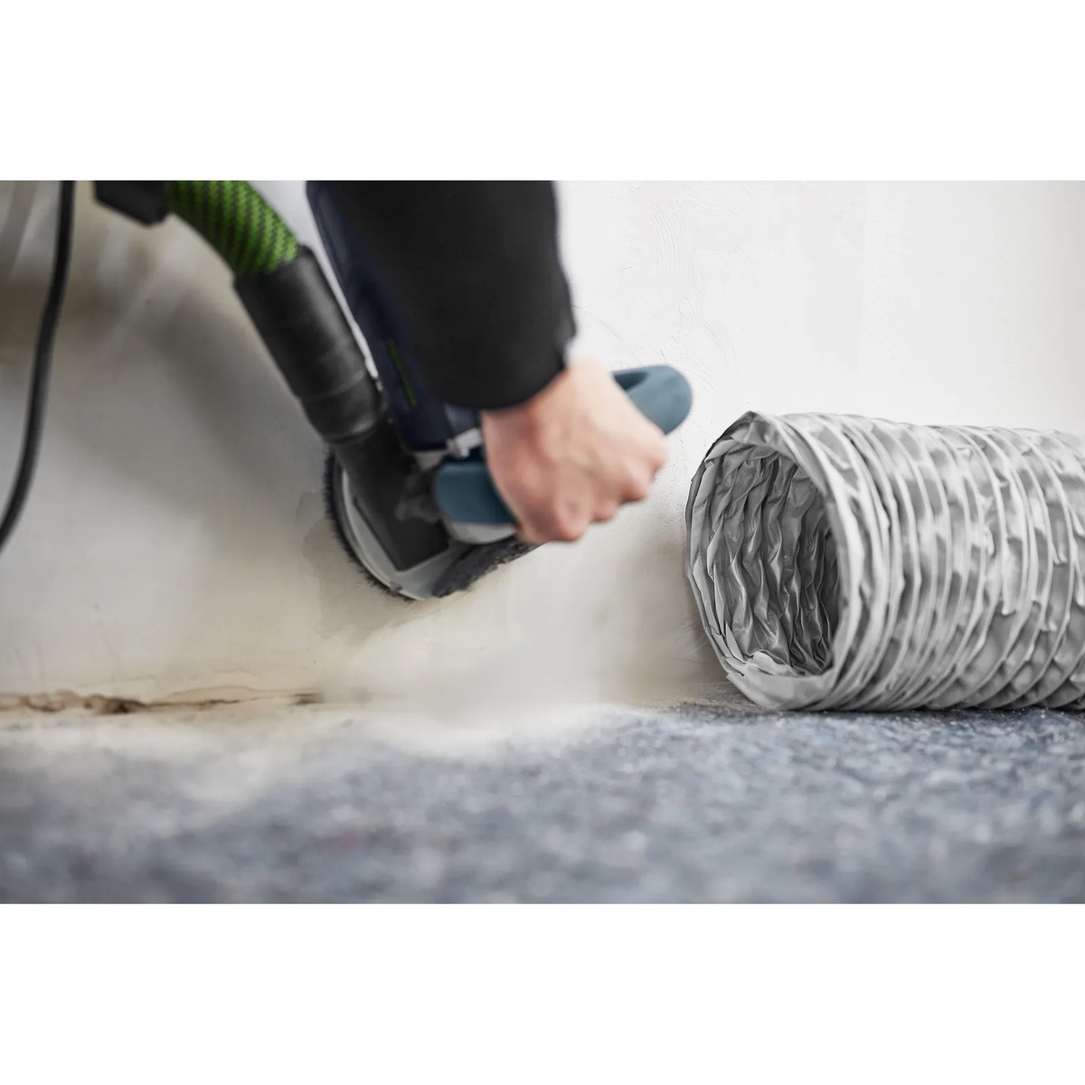Festool 577964 SYS-AIR Air Supply Hose LS-SYS-AIR D200x6m positioned near a sanding tool at a wall for targeted dust collection in a remodel room
