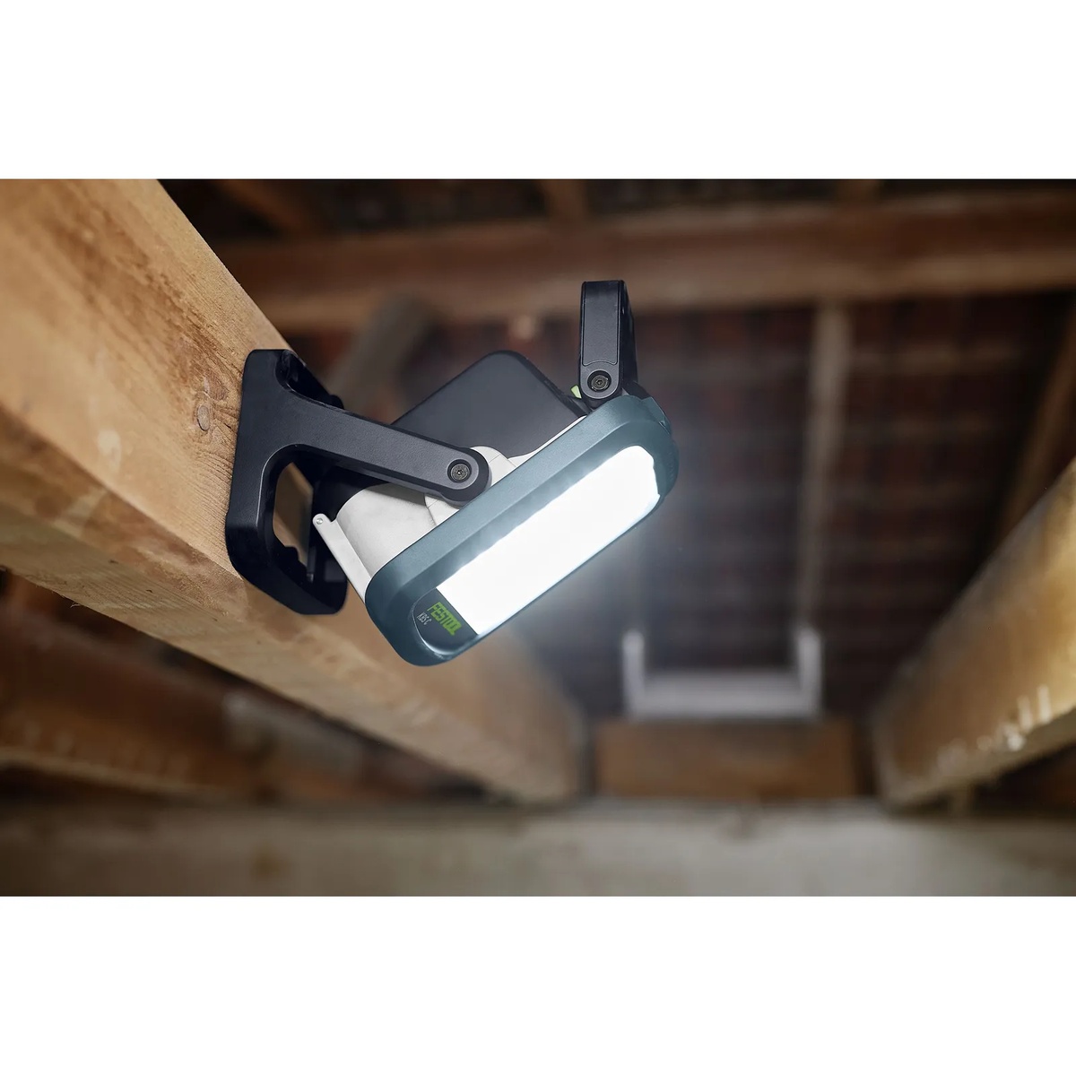 Festool SYSLITE KBS C cordless site light mounted to a wood beam to illuminate overhead framing in a renovation space