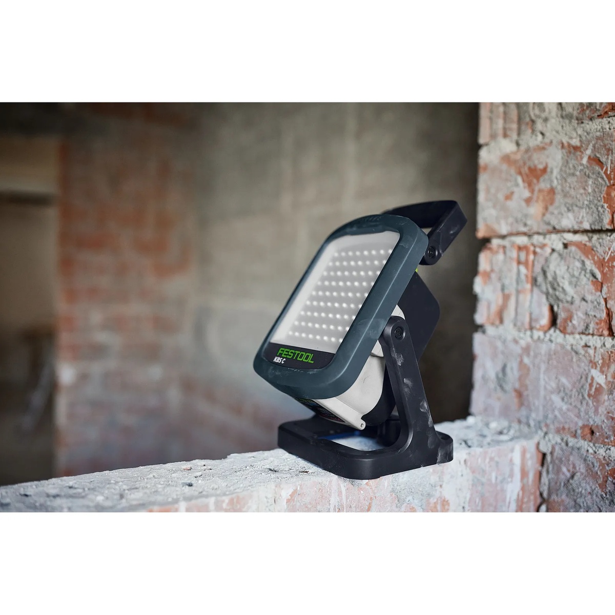 Festool SYSLITE KBS C LED site light set on a masonry wall inside a dusty remodel area
