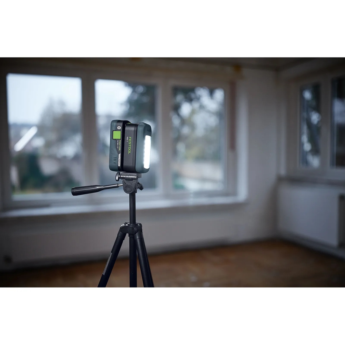 Festool 578128 SYSLITE KAL C Cordless 1200-Lumen Task LED Light mounted on a tripod to illuminate an interior room during remodeling and finish work