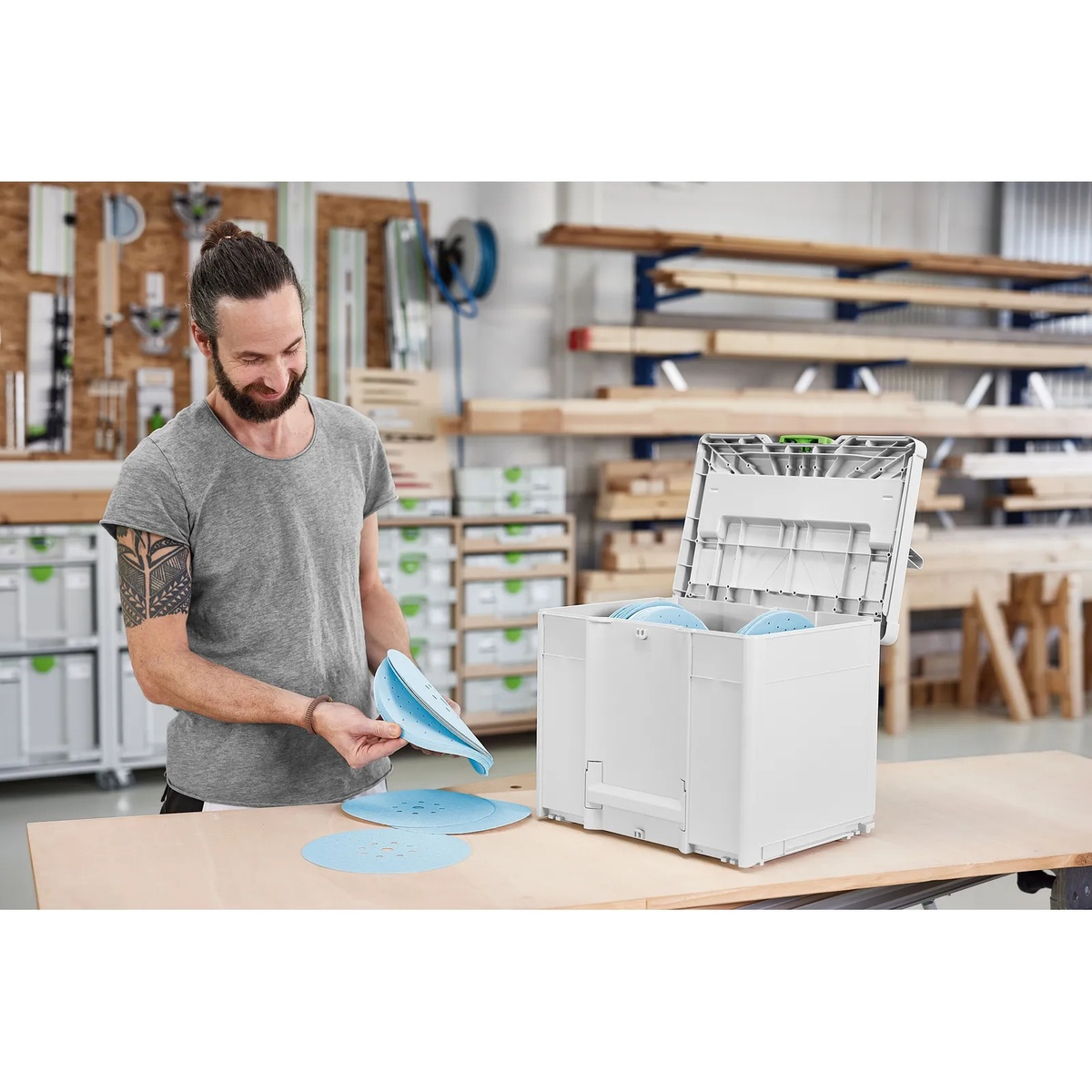 Festool 578281 D225 GR SYS Granat Abrasives Systainer open on a workbench with 225 mm sanding discs being sorted by grit in a shop setting