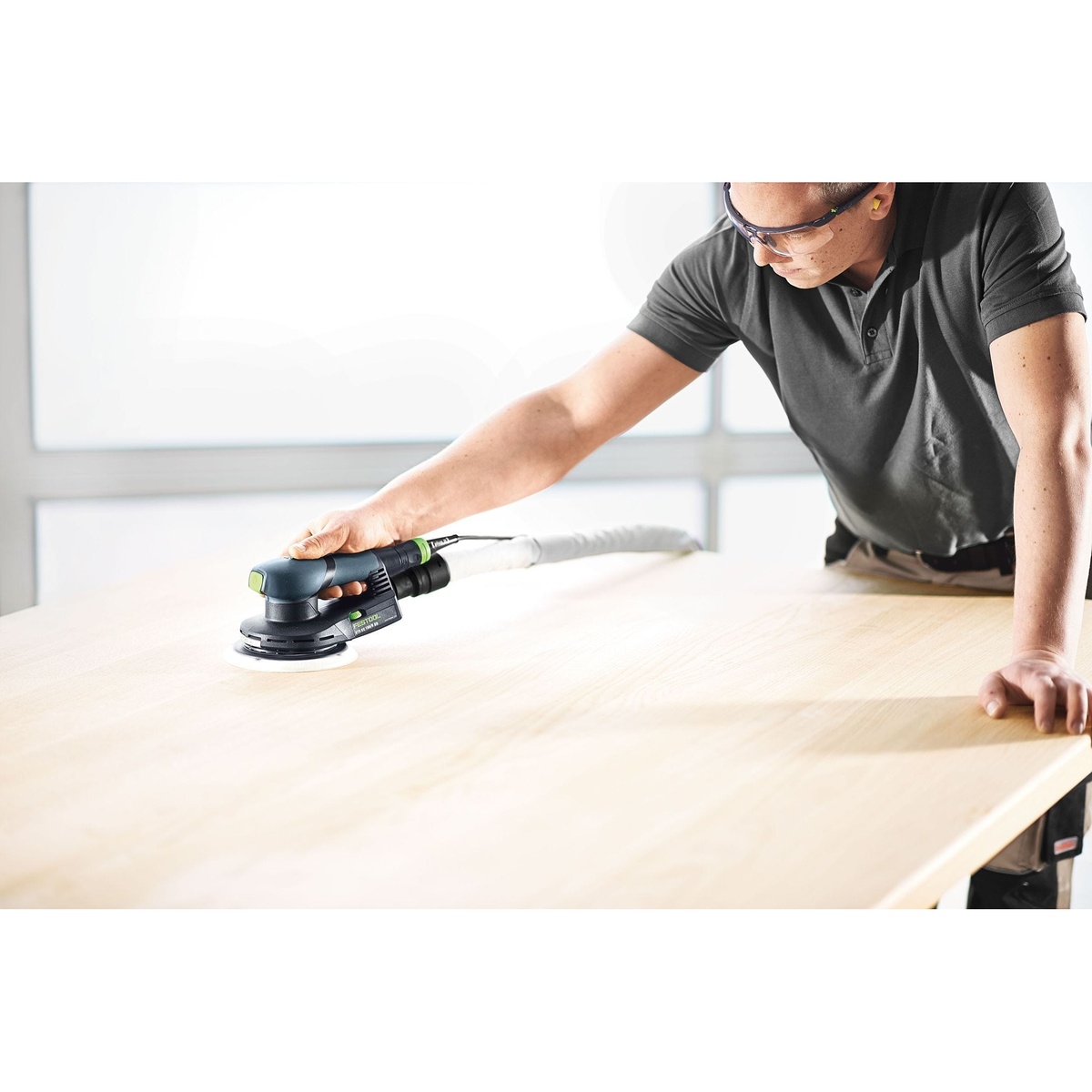 Operator using the Festool ETS EC 150/5 EQ random orbital finish sander on a large wood work surface during finish sanding