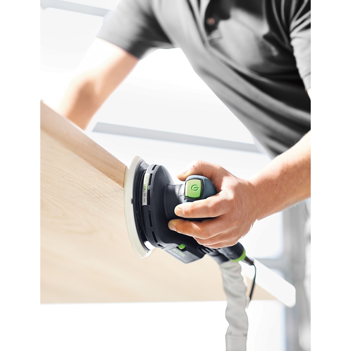 Festool ETS EC 150/3 EQ 150mm compact finish sander sanding a vertical wood panel during finish prep in a workshop
