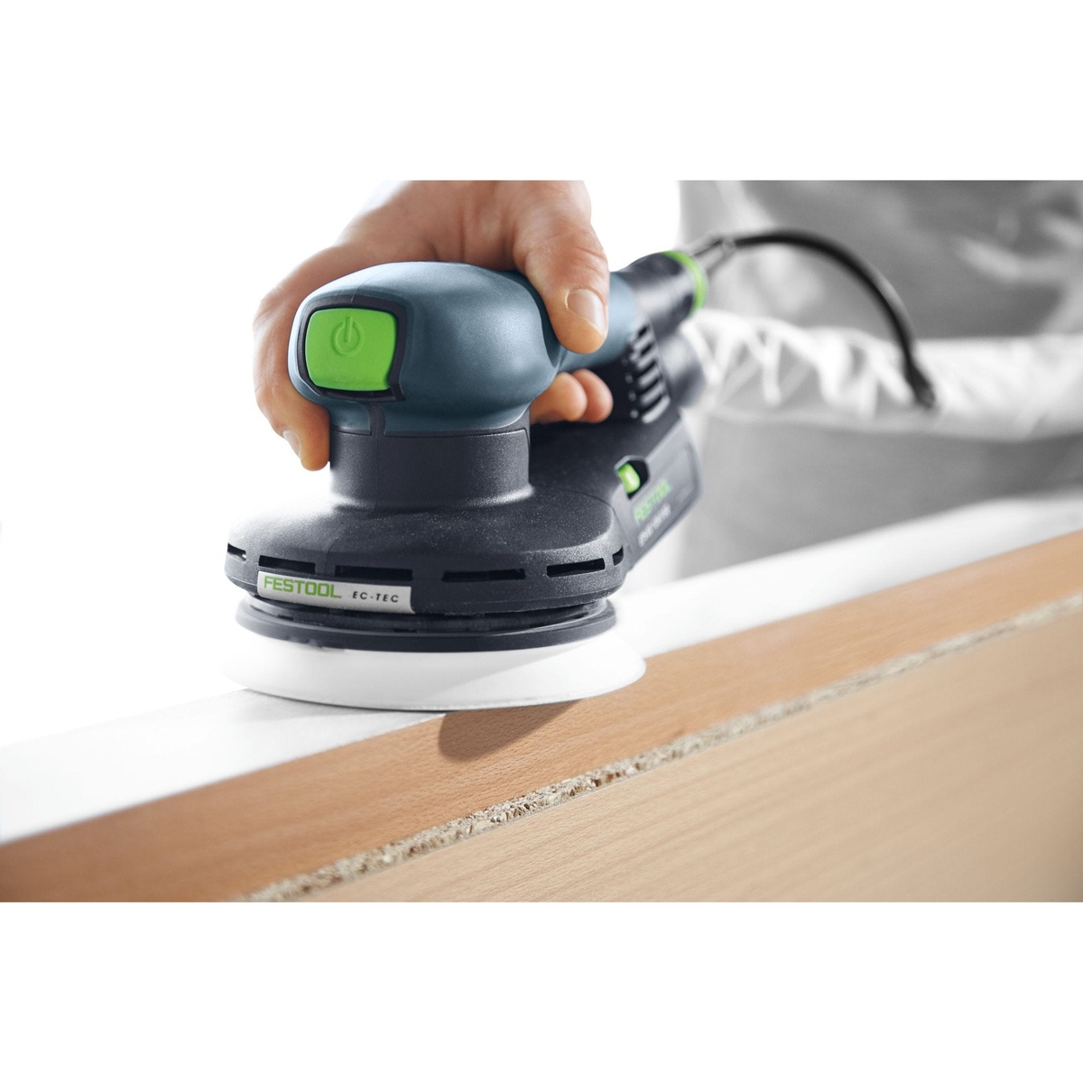 Festool ETS EC 125/3 EQ-Plus compact brushless finish sander smoothing the edge of a wood panel during finish sanding in a workshop setting