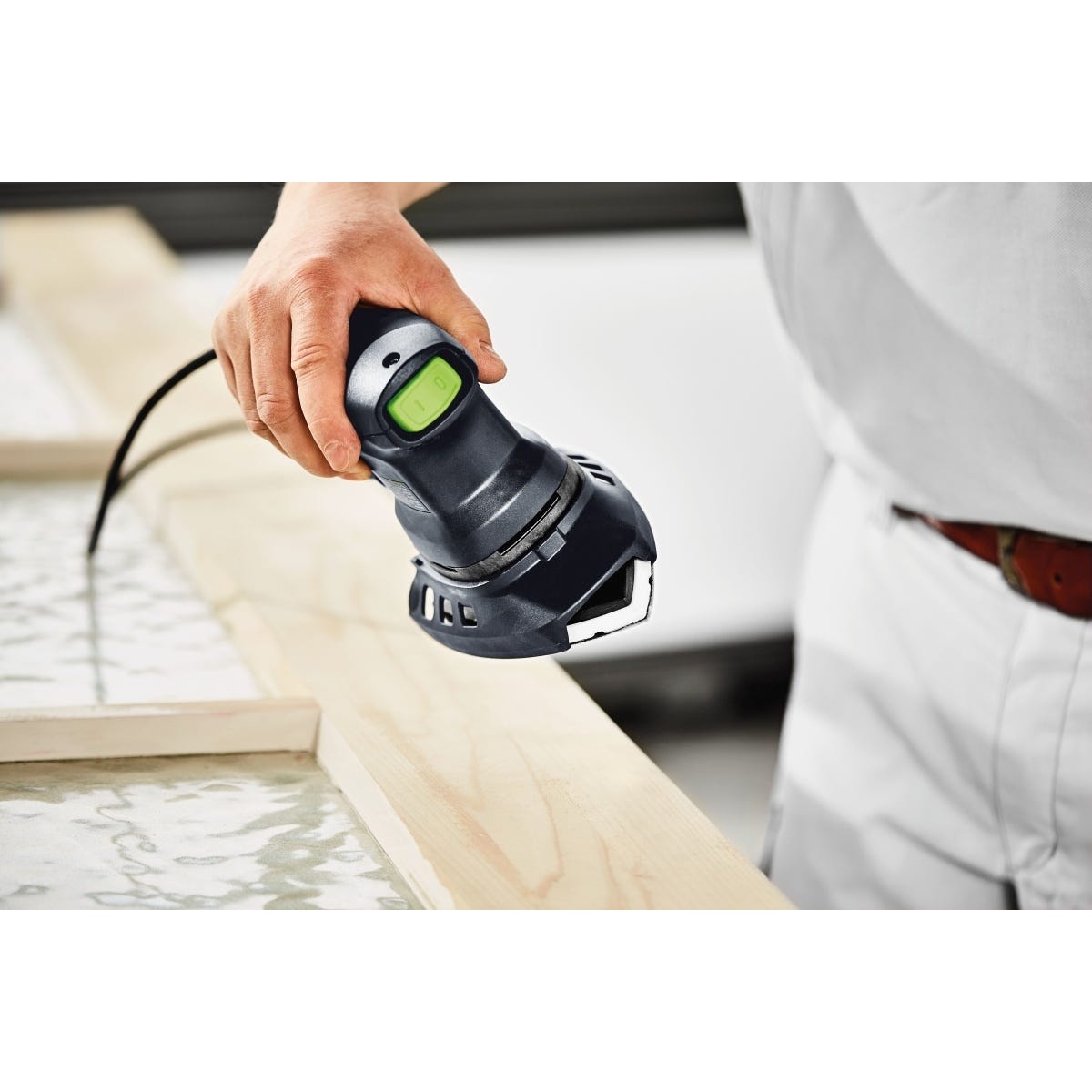 Festool DTS 400 REQ Orbital Sander detail sander working on a wood edge during finish sanding on trim in a shop setting