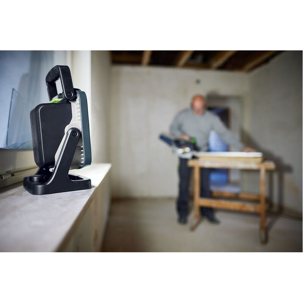 Festool SYSLITE KBS C Cordless 5000-Lumen Site Light lighting an unfinished interior room during renovation work from a windowsill work position