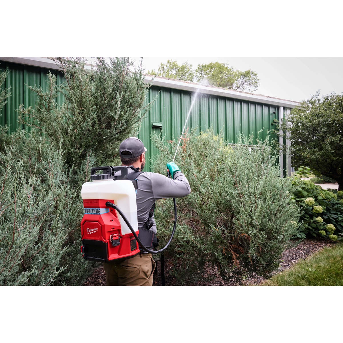 Milwaukee 49-16-19PS 4-Gallon Sprayer Tank Assembly w/ SWITCH-TANK in outdoor vegetation spraying use with extended wand reach and backpack carry