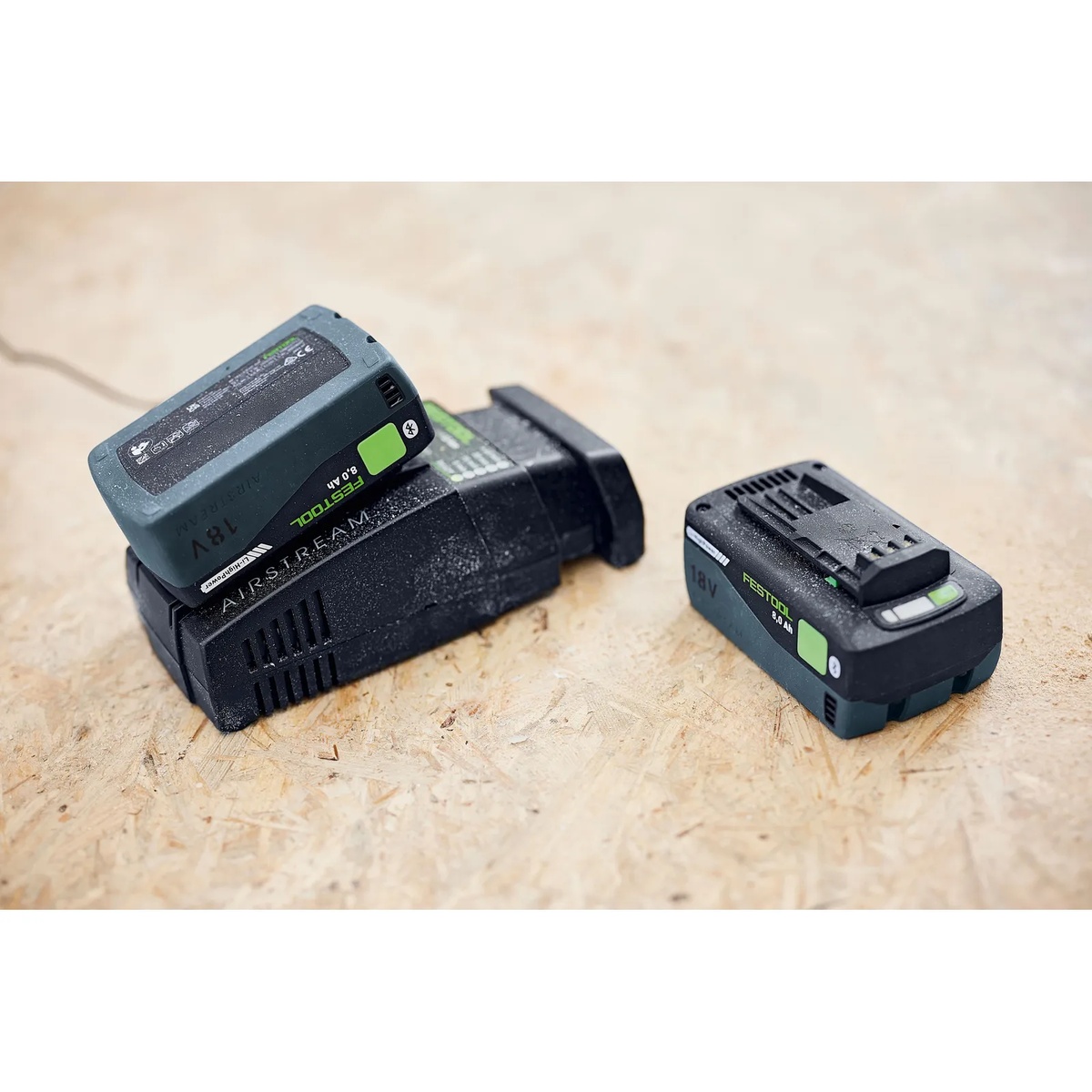 Festool 577324 BP 18 Li 8,0 HP-ASI High Power 8.0Ah Battery Pack charging on an AIRSTREAM charger on a wood workbench