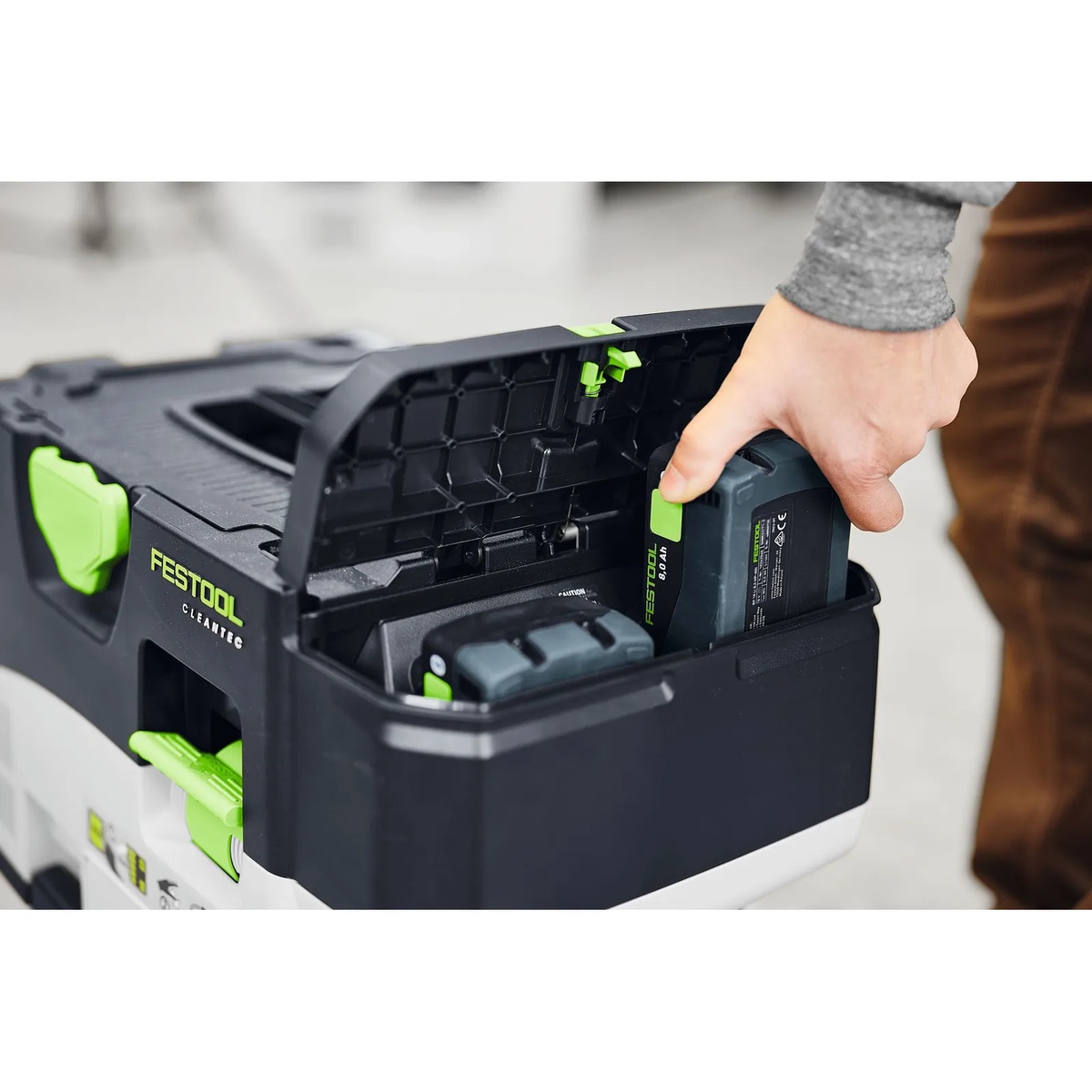 Festool 577324 BP 18 Li 8,0 HP-ASI High Power 8.0Ah Battery Pack being loaded into a Festool CLEANTEC mobile dust extractor on a jobsite