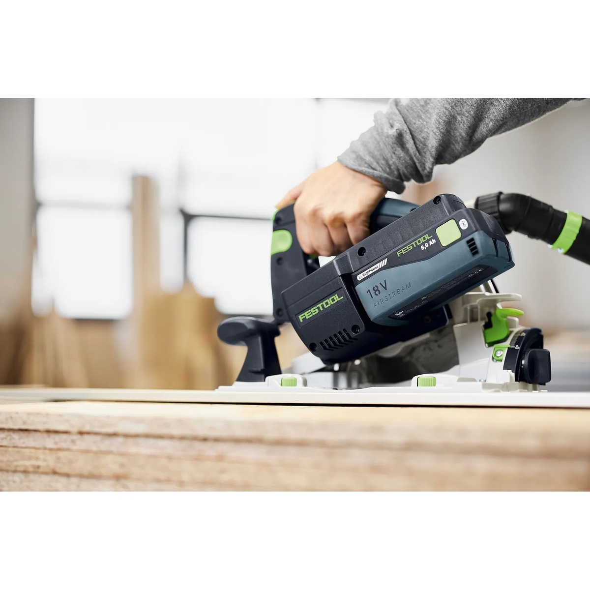Festool 577324 BP 18 Li 8,0 HP-ASI High Power 8.0Ah Battery Pack installed on a cordless circular saw cutting sheet material in a workshop