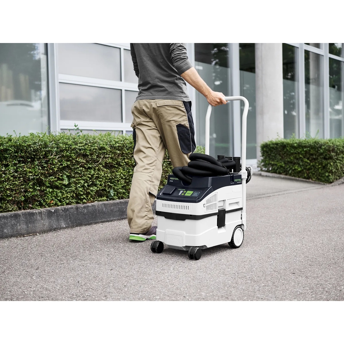 Festool 578441 CLEANTEC CT 15 E HEPA Dust Extractor being rolled outdoors between work areas for jobsite cleanup and transport