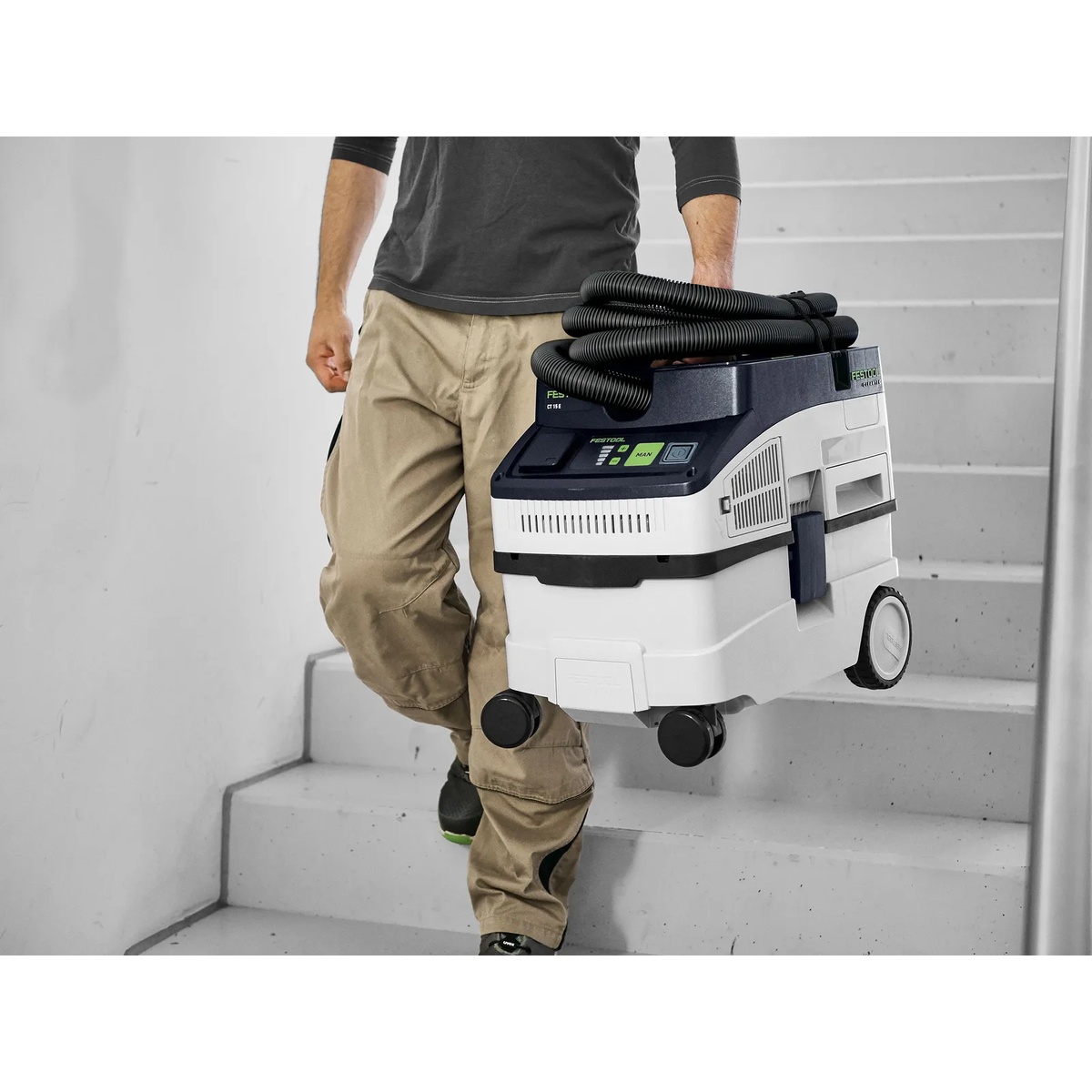 Festool 578441 CLEANTEC CT 15 E HEPA Dust Extractor being carried up stairs for indoor remodel and cleanup work