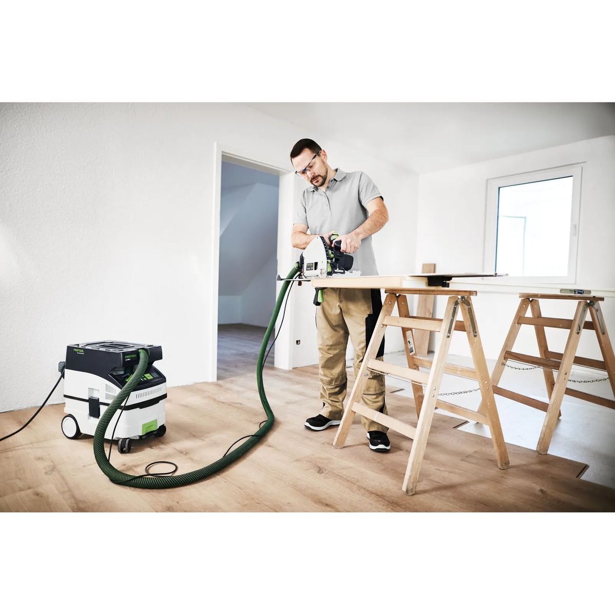 Festool 578512 CT MIDI I HEPA Bluetooth Dust Extractor connected to a track saw while cutting sheet material indoors during finish carpentry work